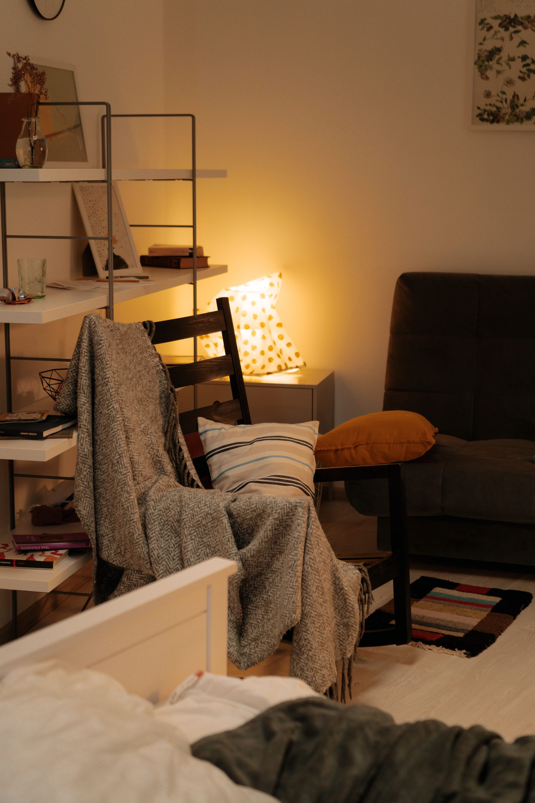 A cozy reading nook with cushions, blanket, and warm lighting for relaxation.