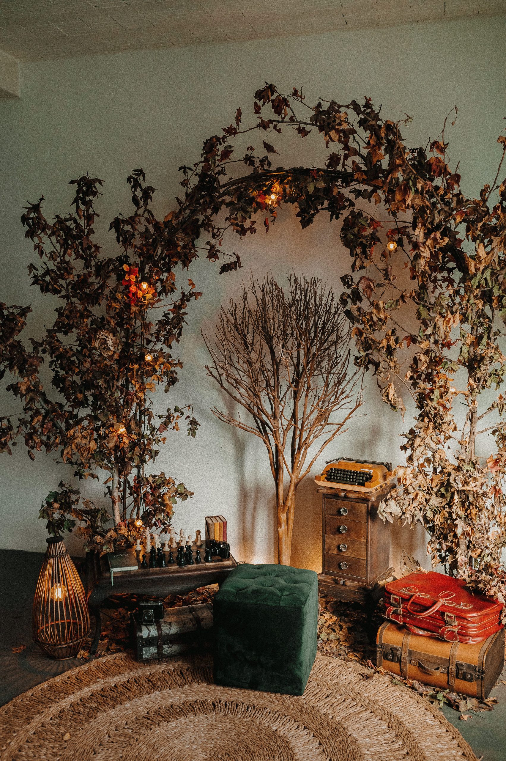 A cozy vintage interior decorated with autumn leaves, typewriter, and suitcases.
