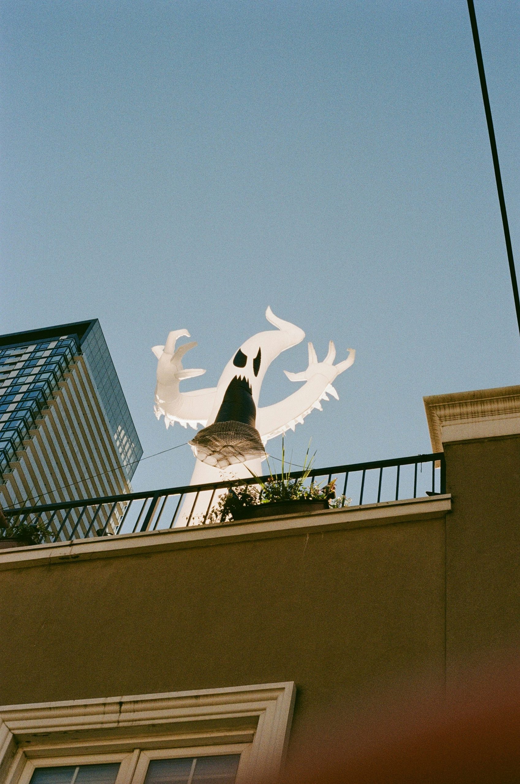 A ghost decoration on a balcony with a building background