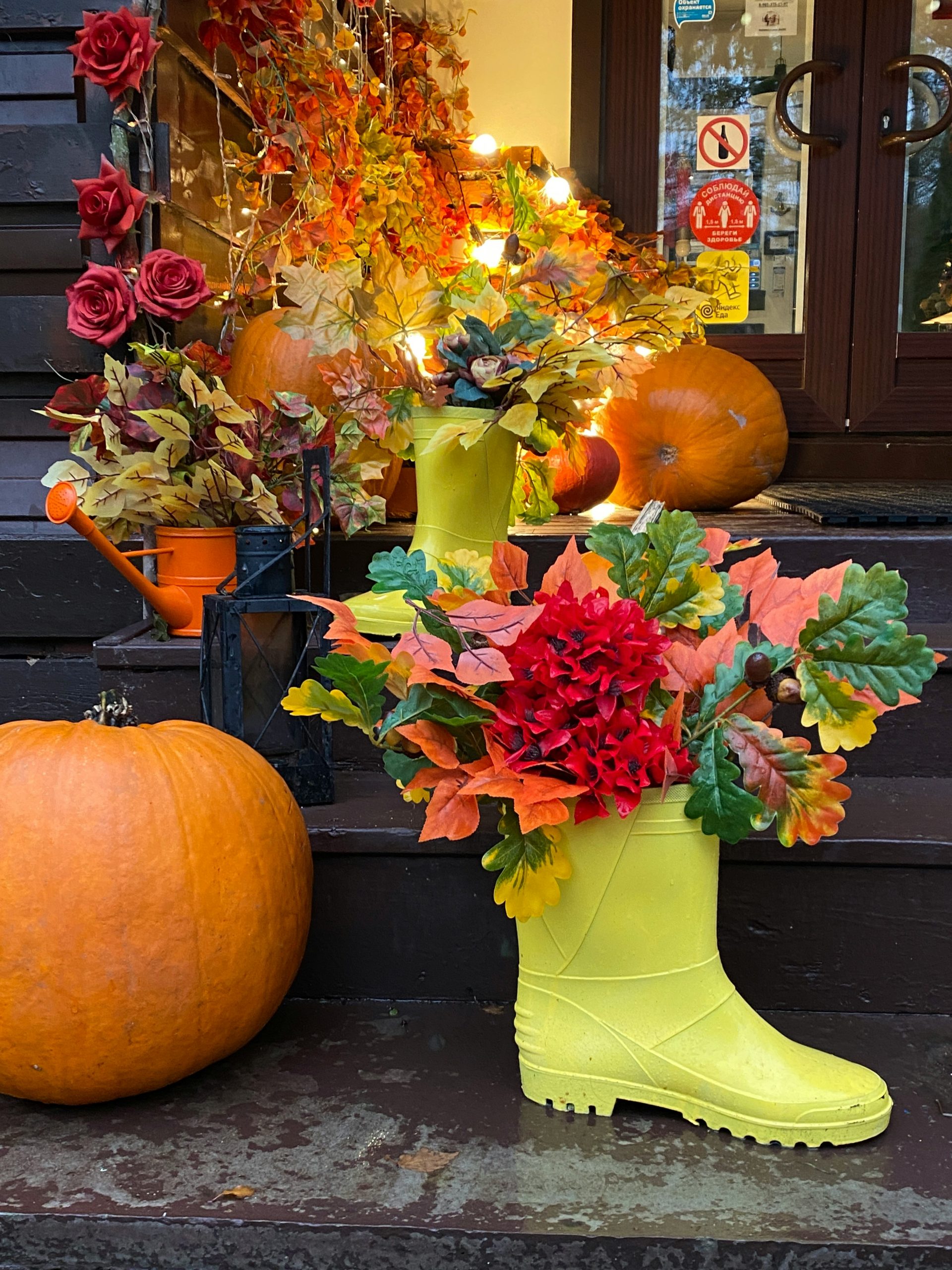 a pair of yellow boots sitting on a step next to a pumpkin