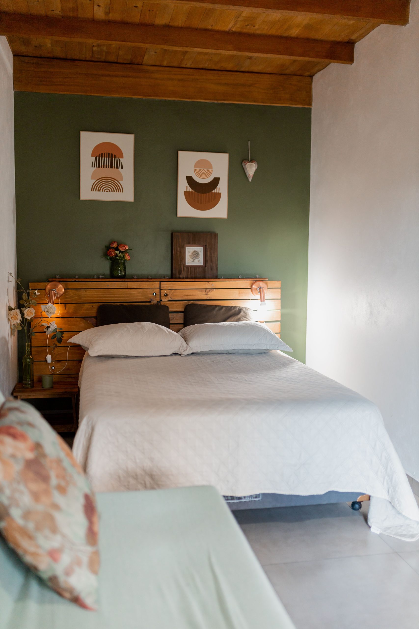 A stylish bedroom with modern art, wooden accents, and a cozy atmosphere.