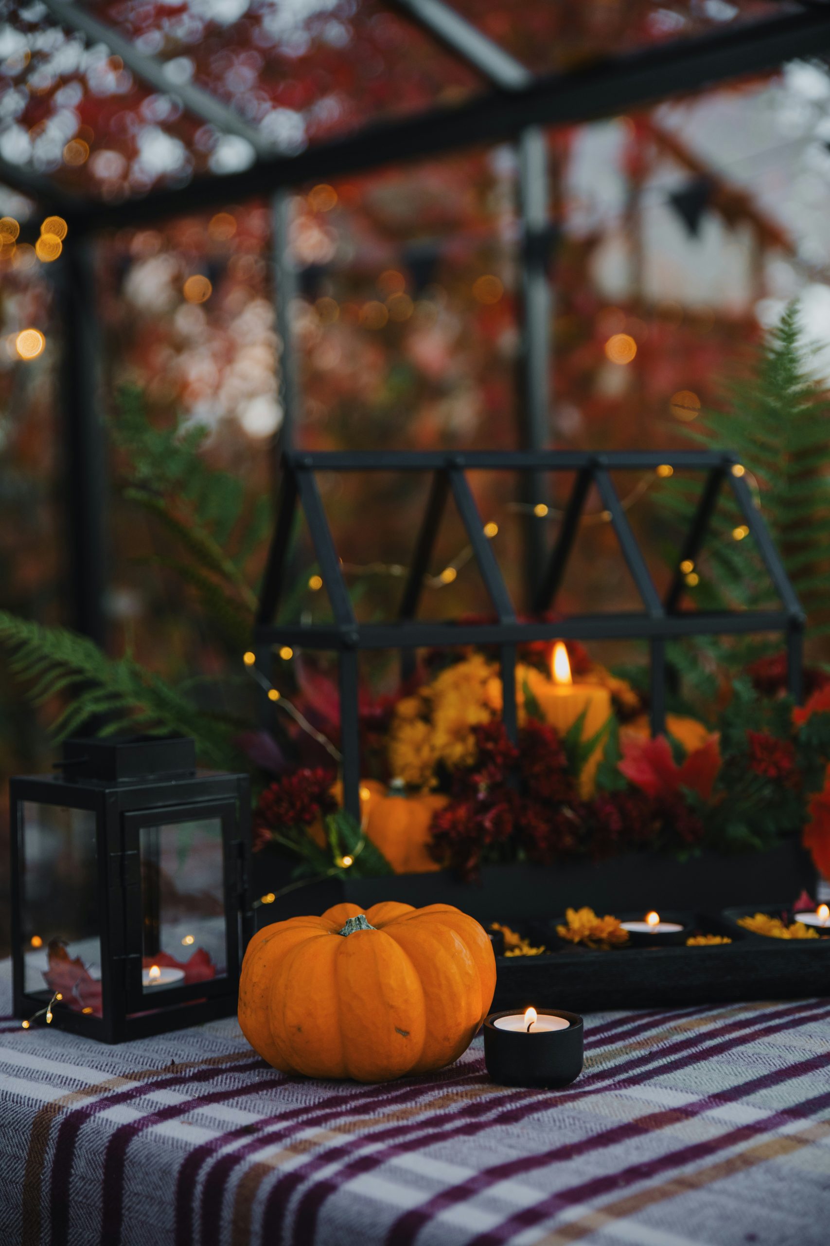 a table with a couple of pumpkins and a candle on it