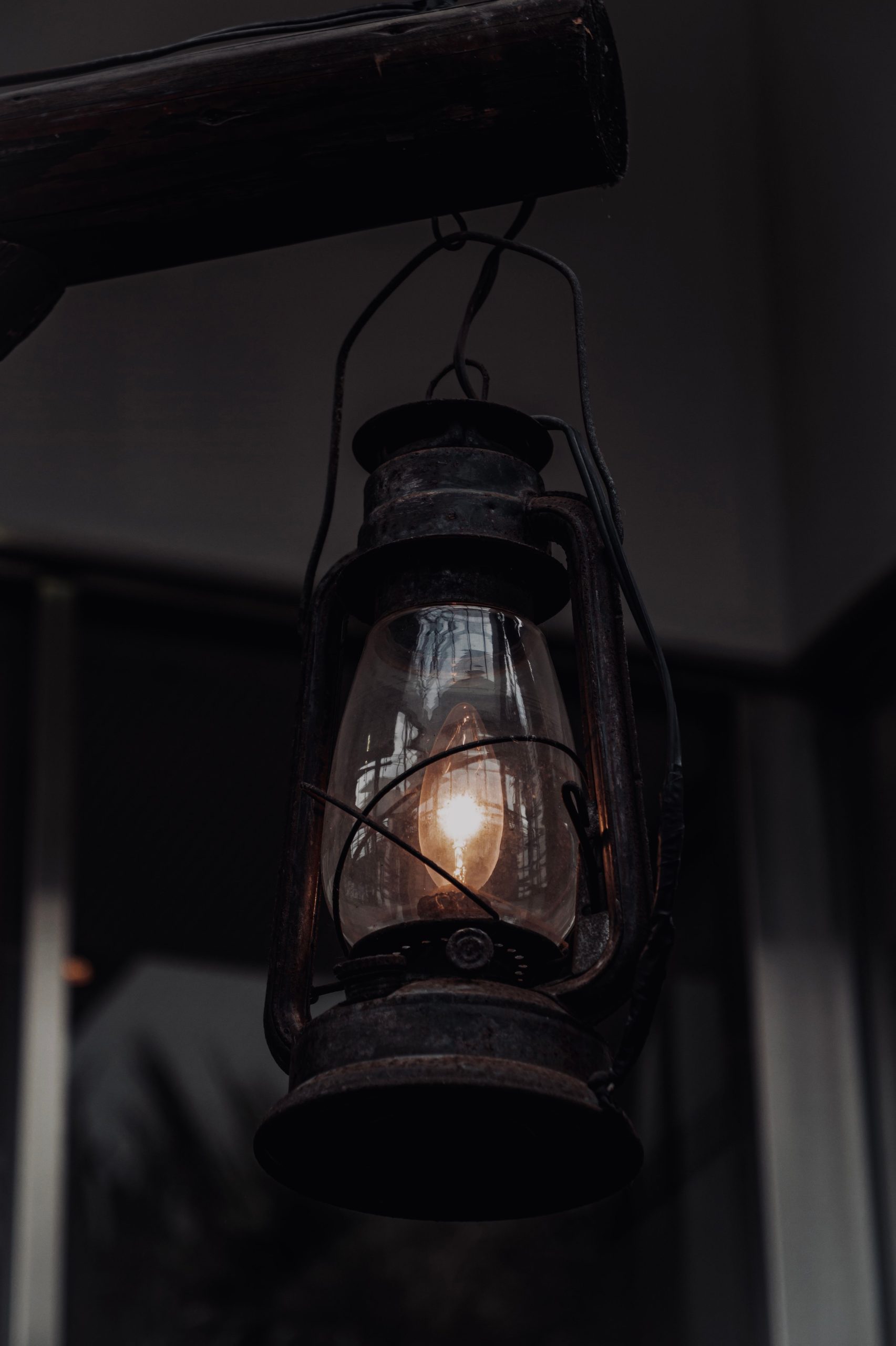 A vintage lantern hanging indoors, creating a moody atmosphere in Toyohashi, Japan.