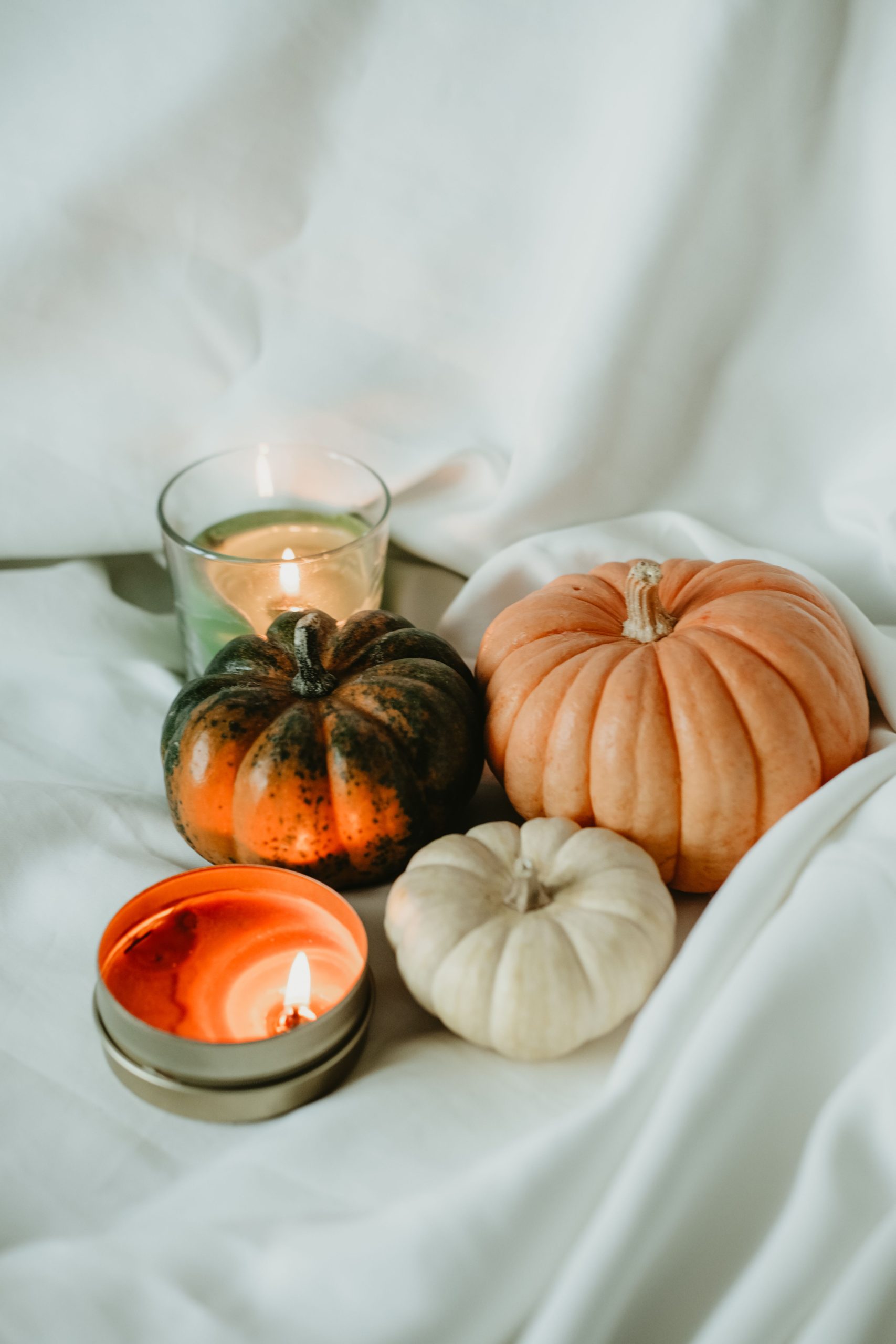 A warm autumn setting with pumpkins and candles for a festive mood.