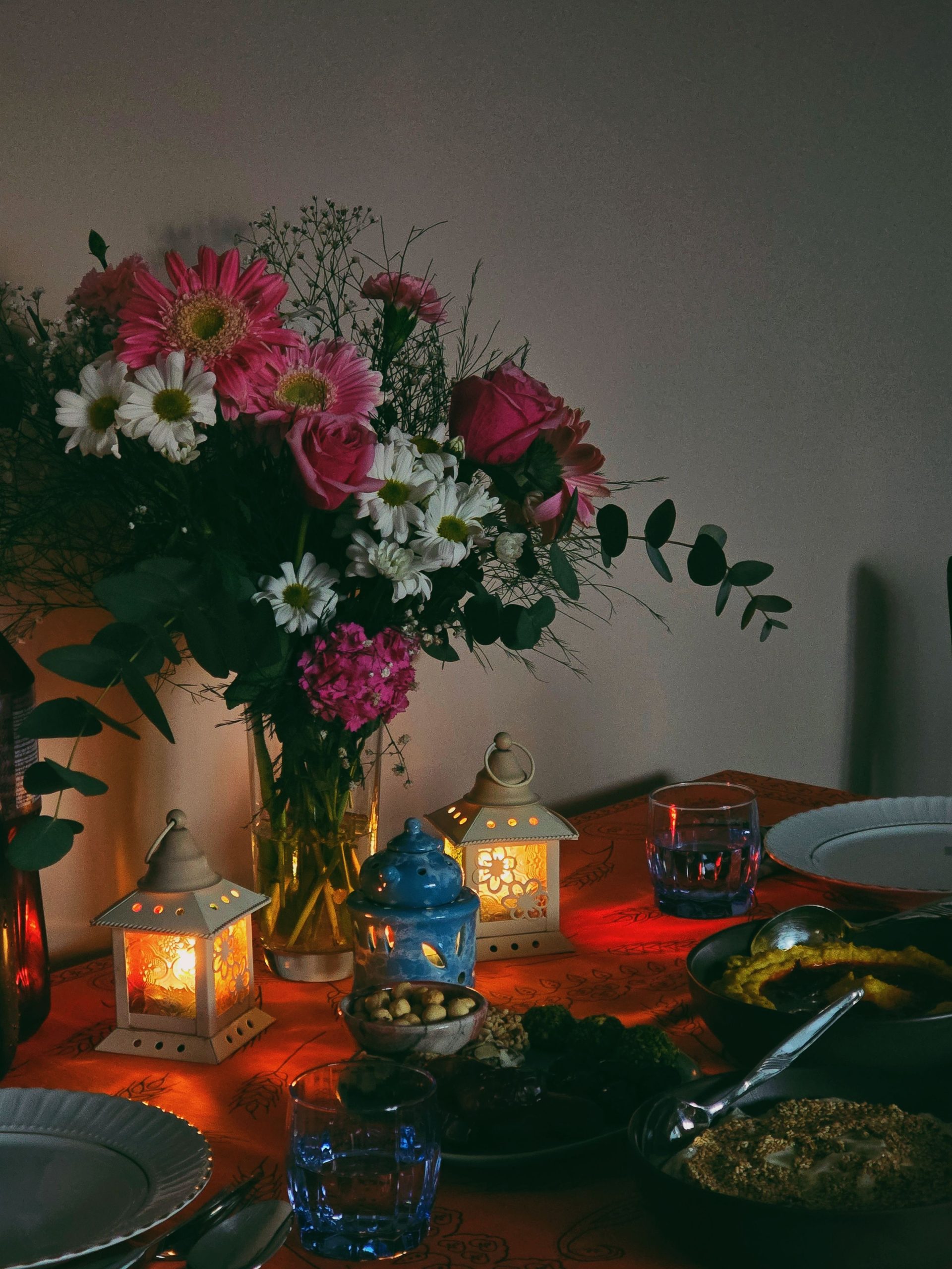 A warm table setting with flowers and candles, creating a cozy dining atmosphere.