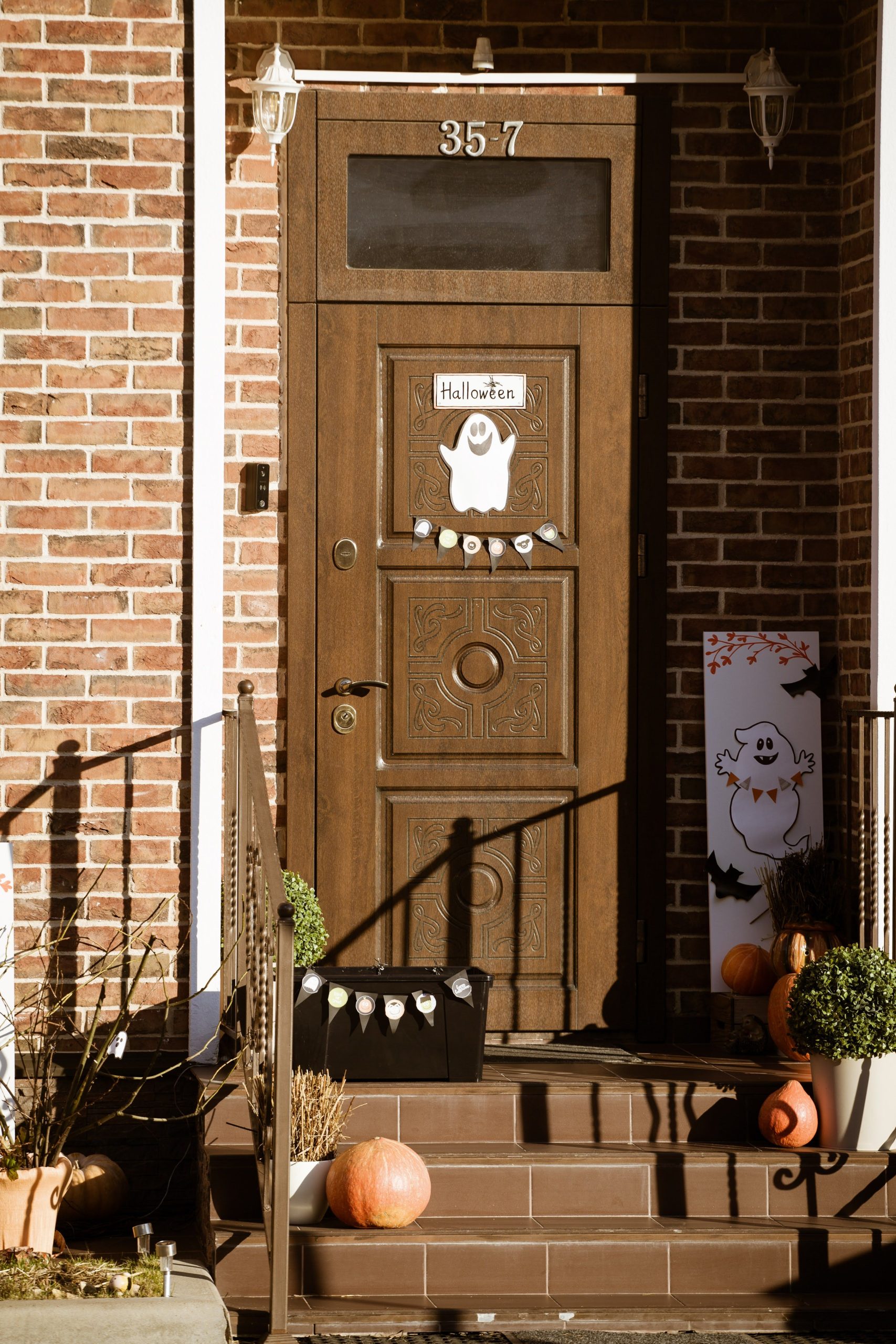 A warm wooden entrance adorned with Halloween decorations and pumpkins.