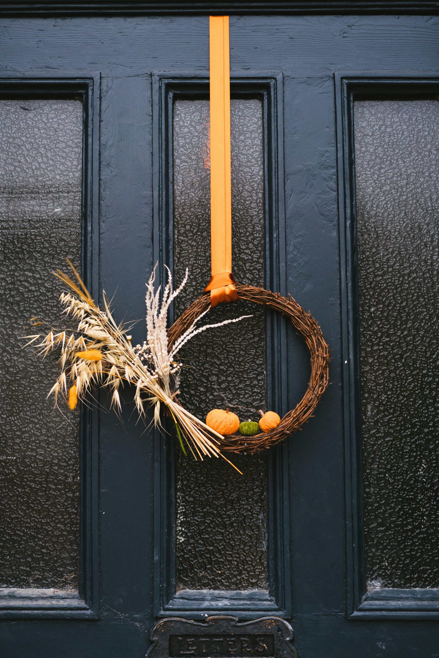 A wreath on a door with a yellow ribbon