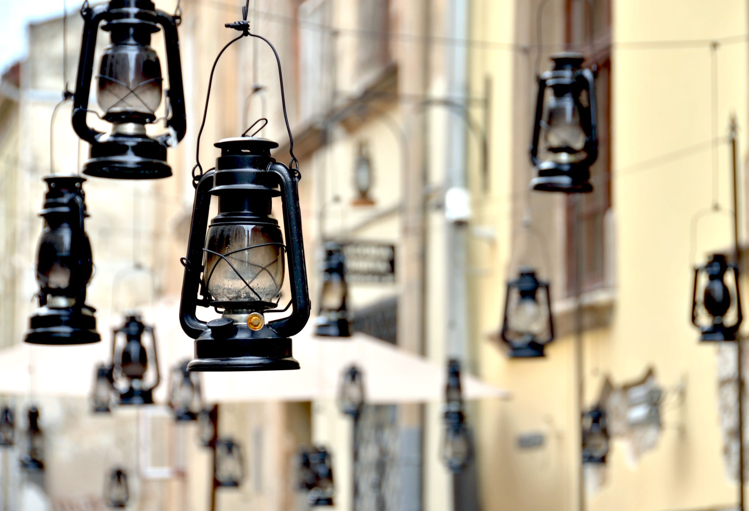 Atmospheric vintage kerosene lanterns hanging in an outdoor setting, creating a nostalgic feel.
