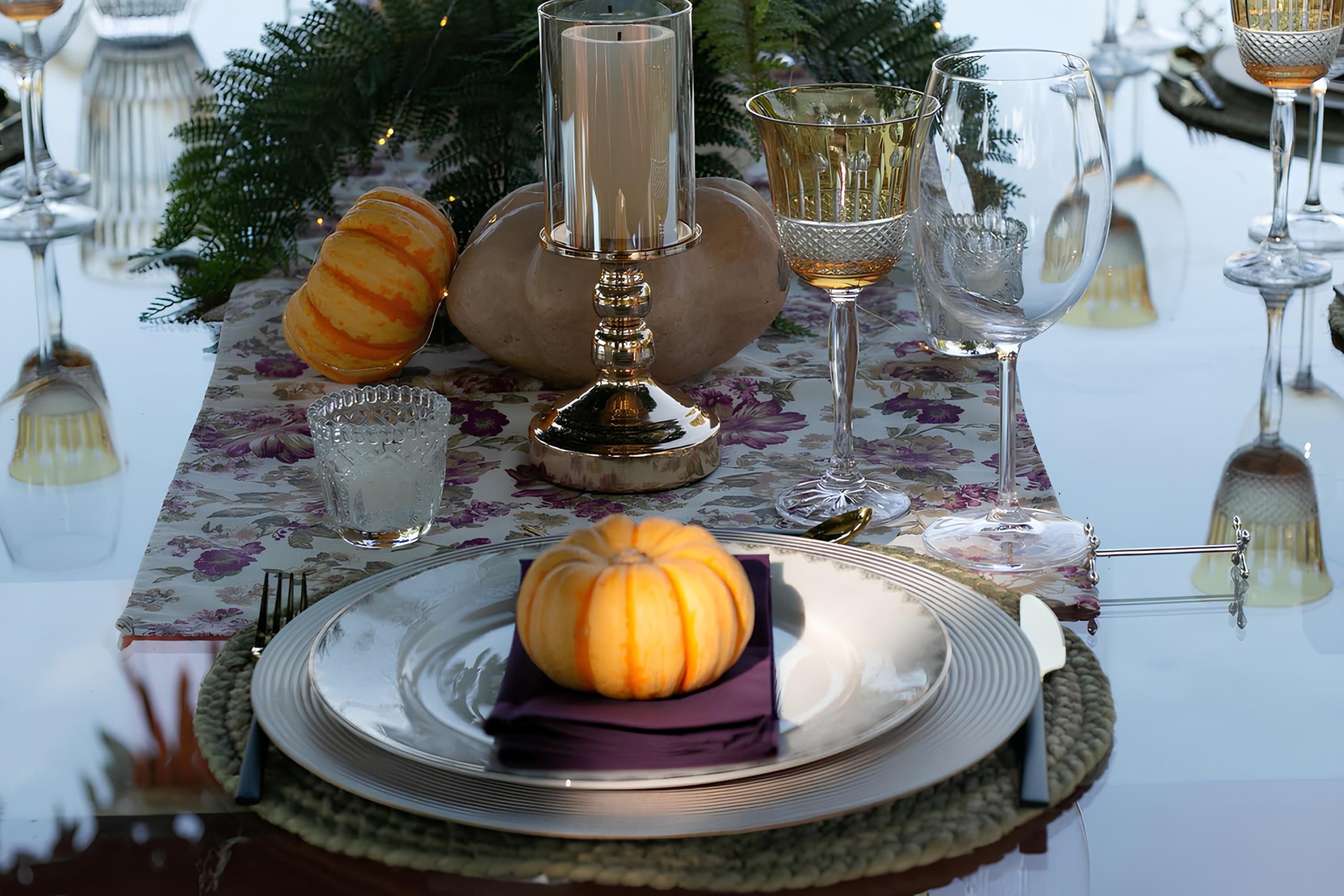 Autumn-themed table setting with pumpkins and elegant glassware for festive dining.