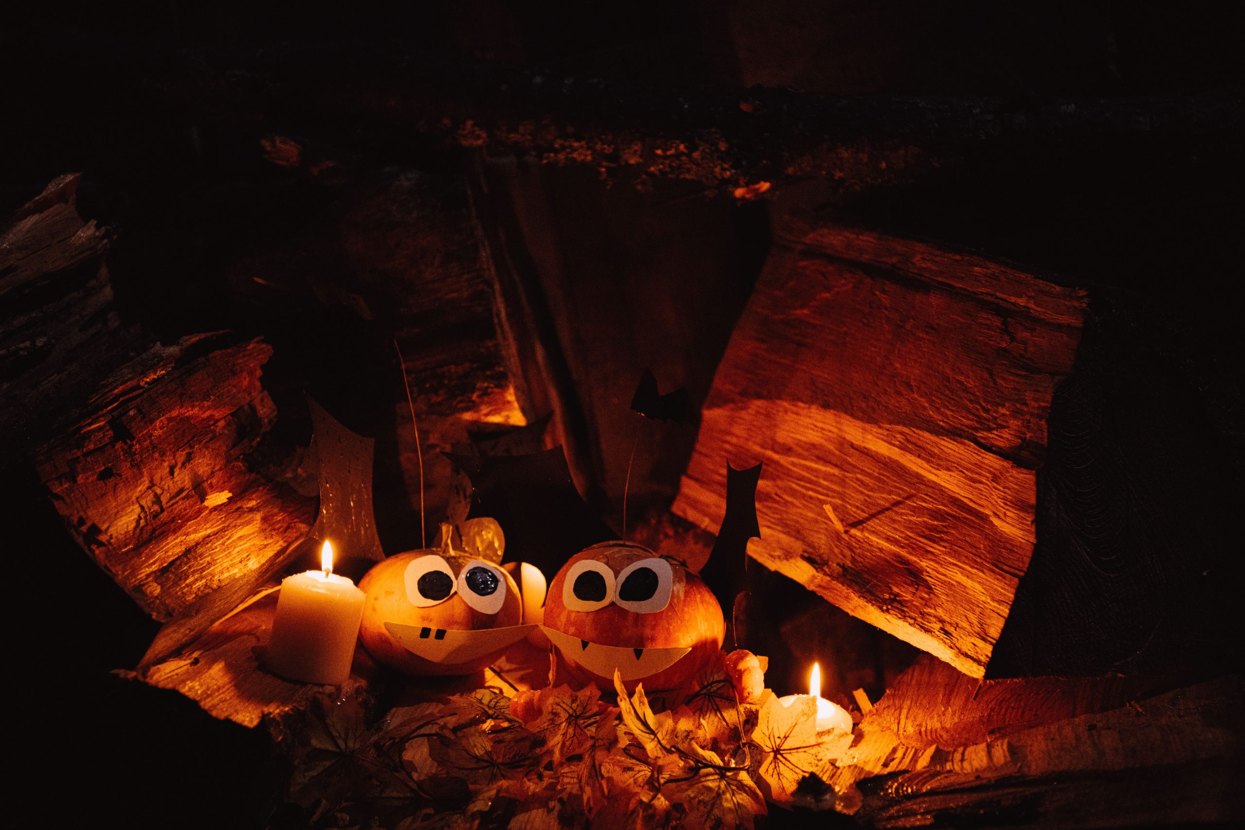 Charming jack-o'-lanterns with candles in a cozy autumn setting, perfect for Halloween atmosphere.