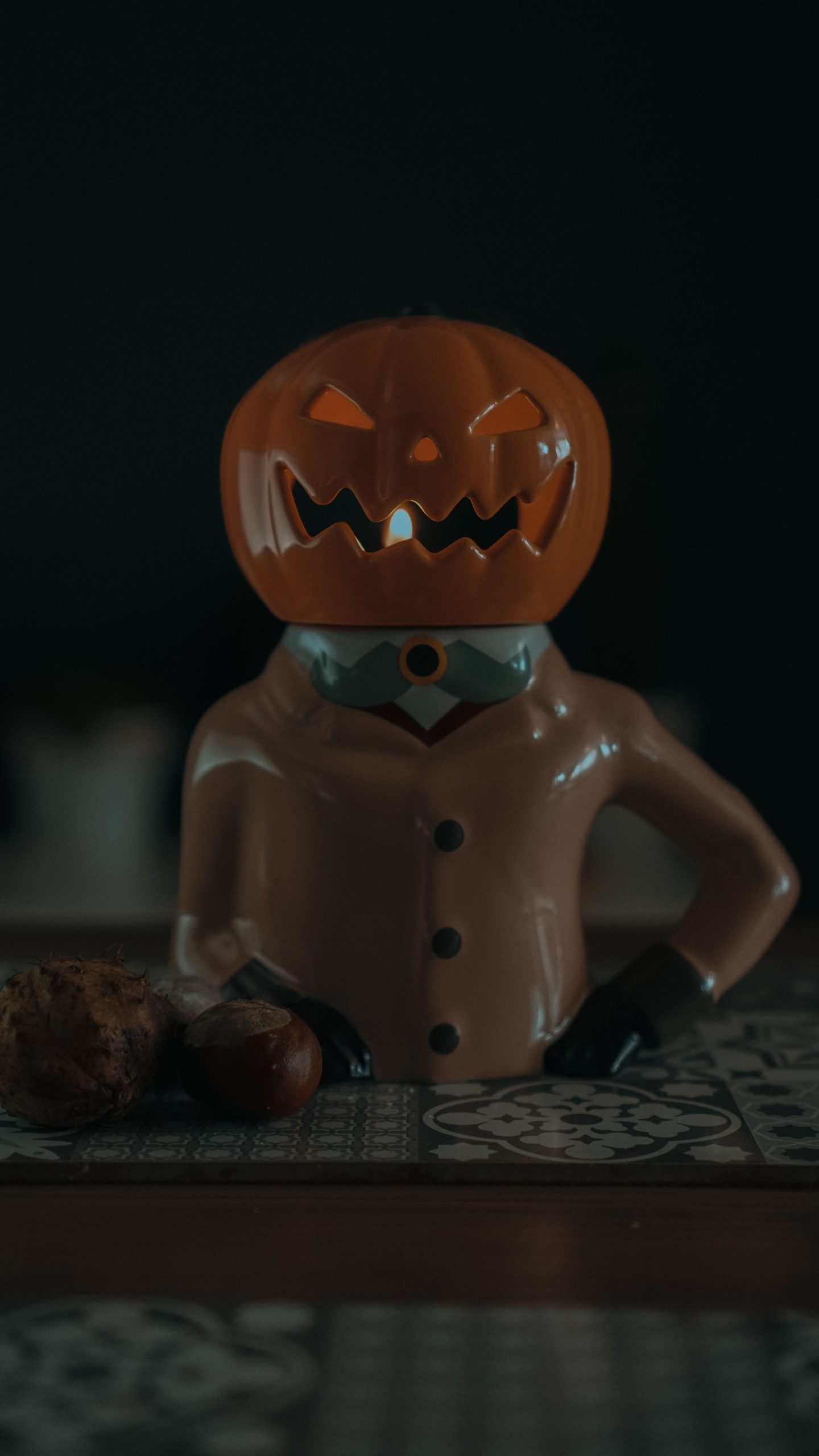 Close-up of a spooky carved pumpkin figurine indoors, perfect for Halloween decor.