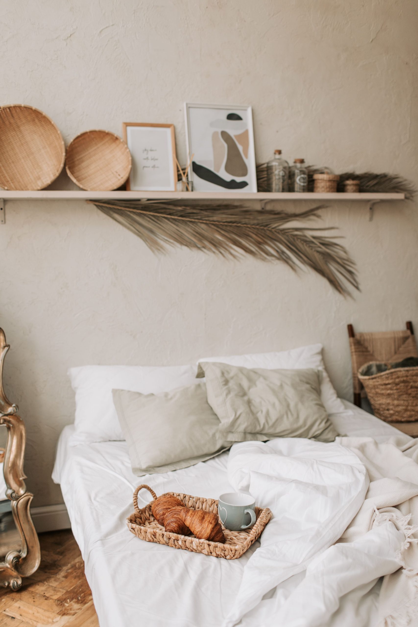 Comfortable bed setting with croissants and coffee, perfect for morning relaxation.