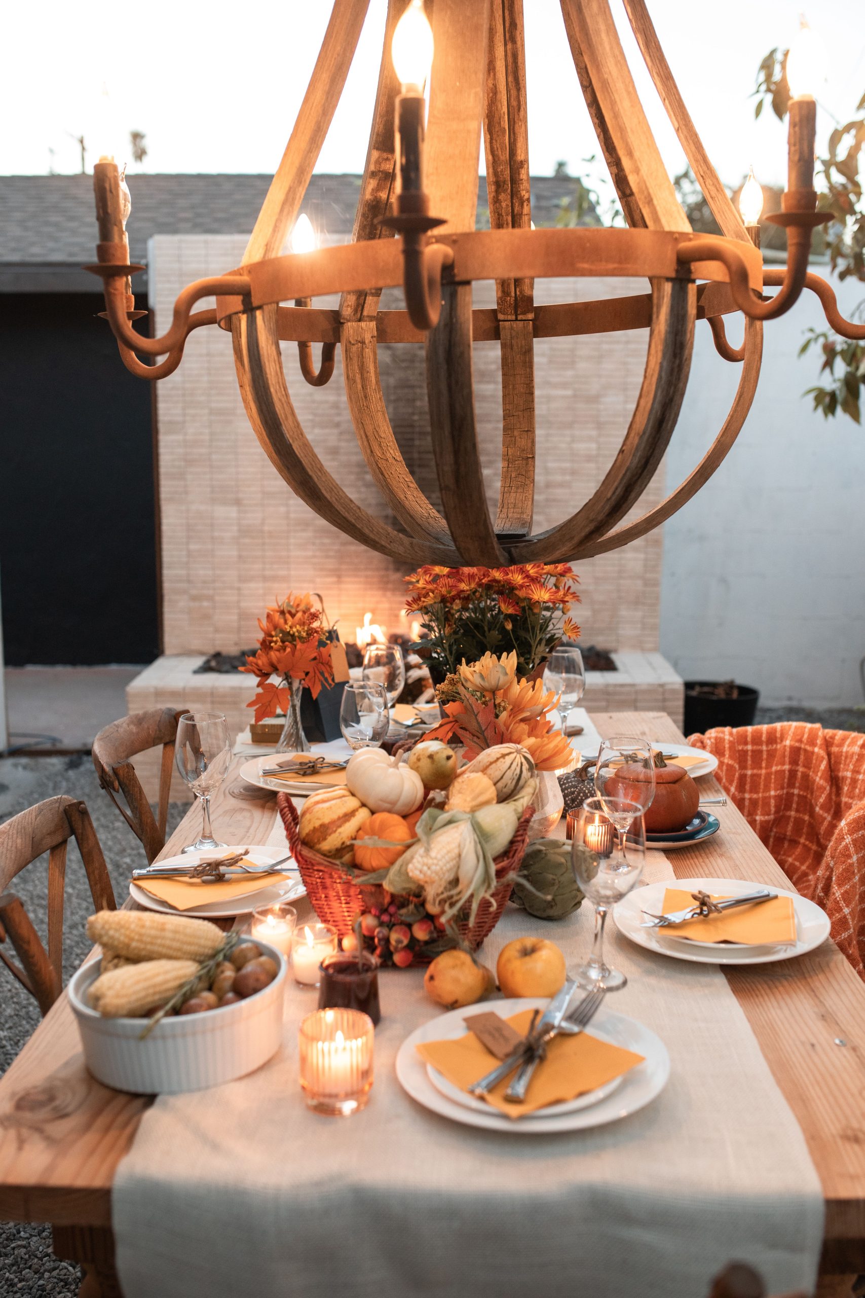 Cozy fall tablescape with pumpkins, candles, and rustic decor.