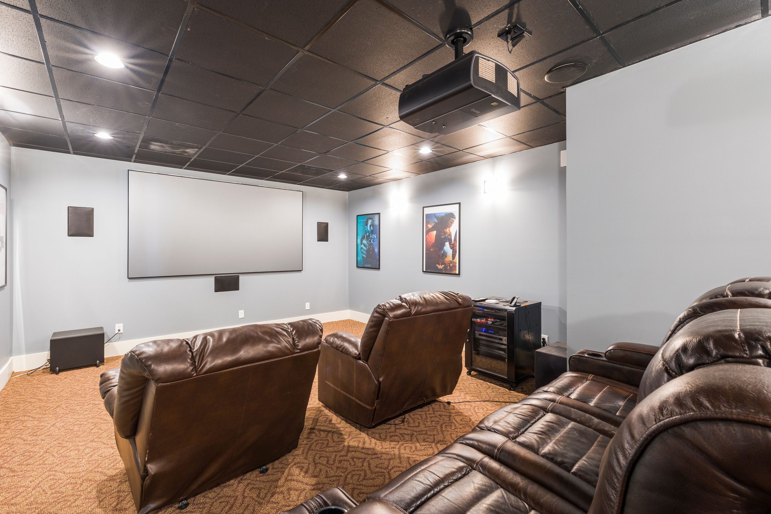Cozy home theater setup with plush leather recliners and modern audiovisual equipment.