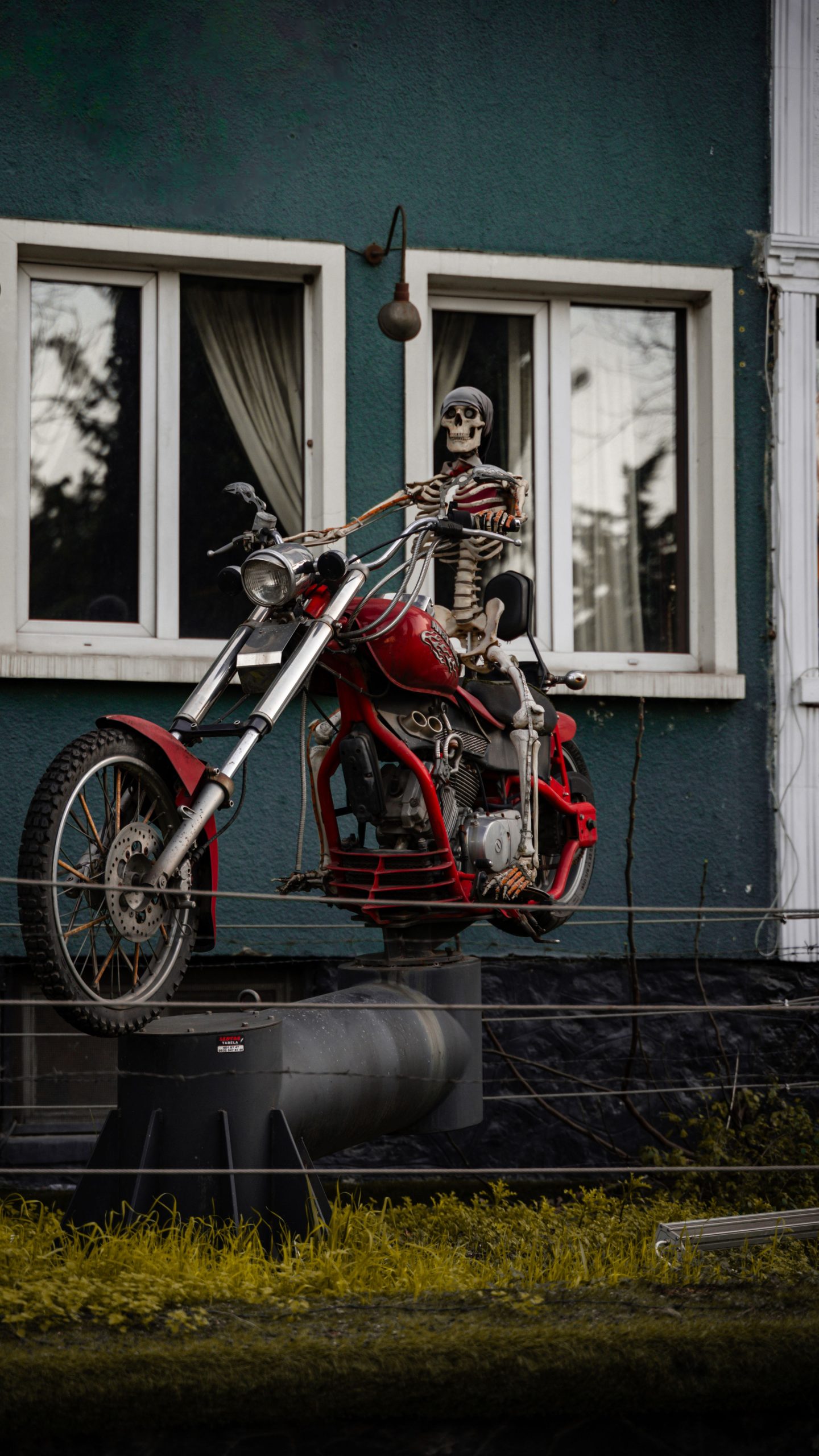 Eerie skeleton display on motorcycle outside a teal house in Bursa.