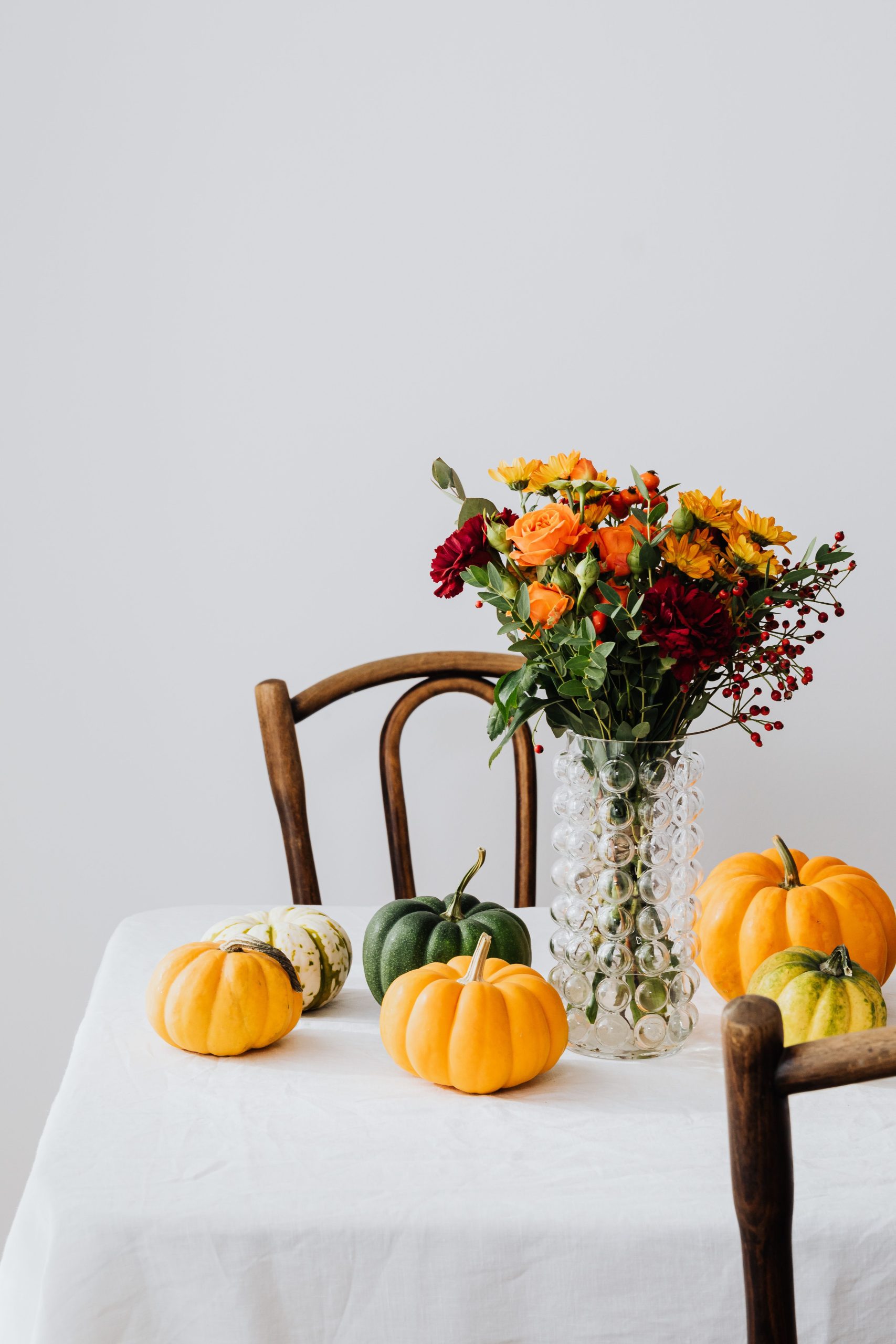 Elegant still life of autumn flowers and pumpkins on a table.
