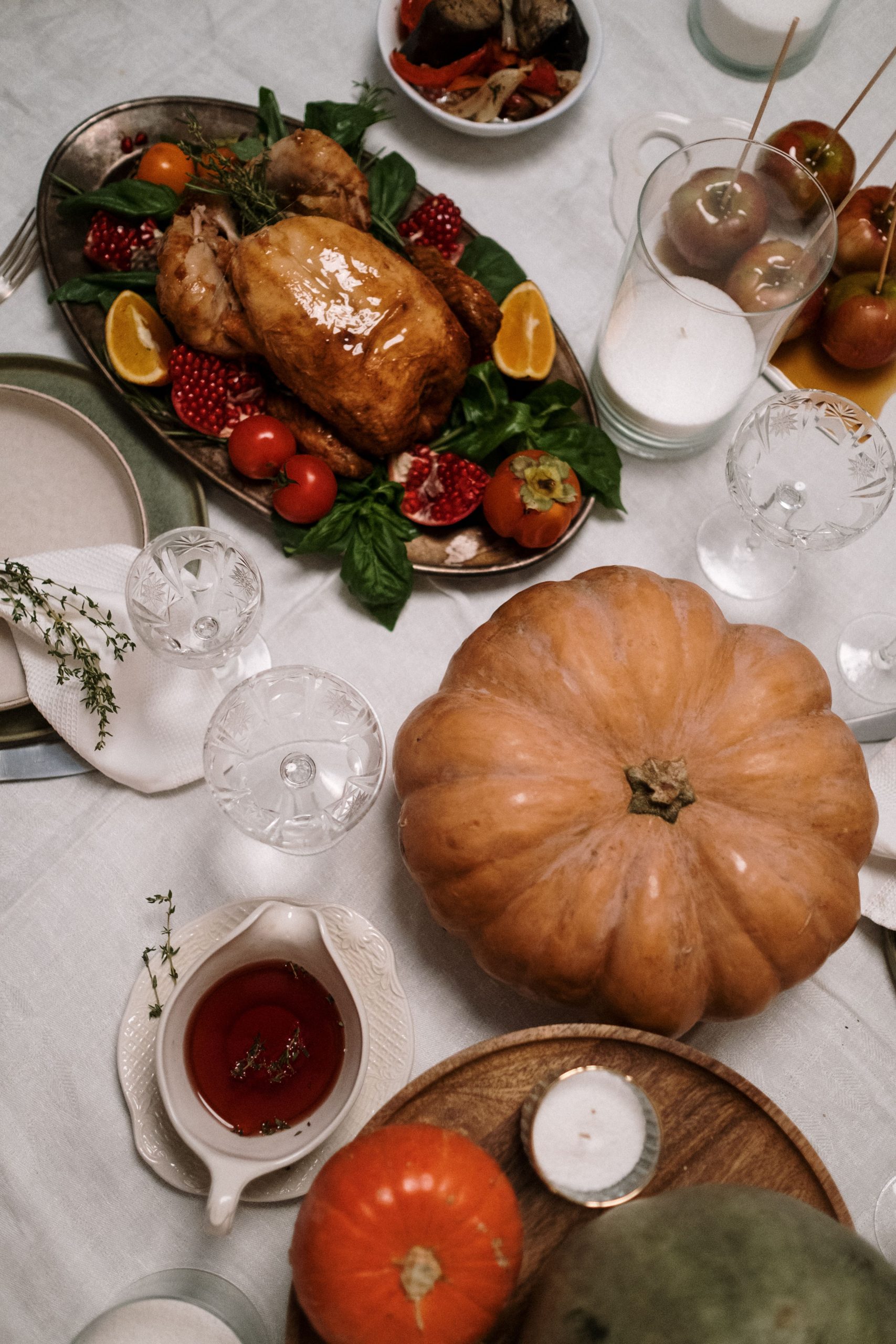 Elegant Thanksgiving table setting with roasted turkey and seasonal decorations.