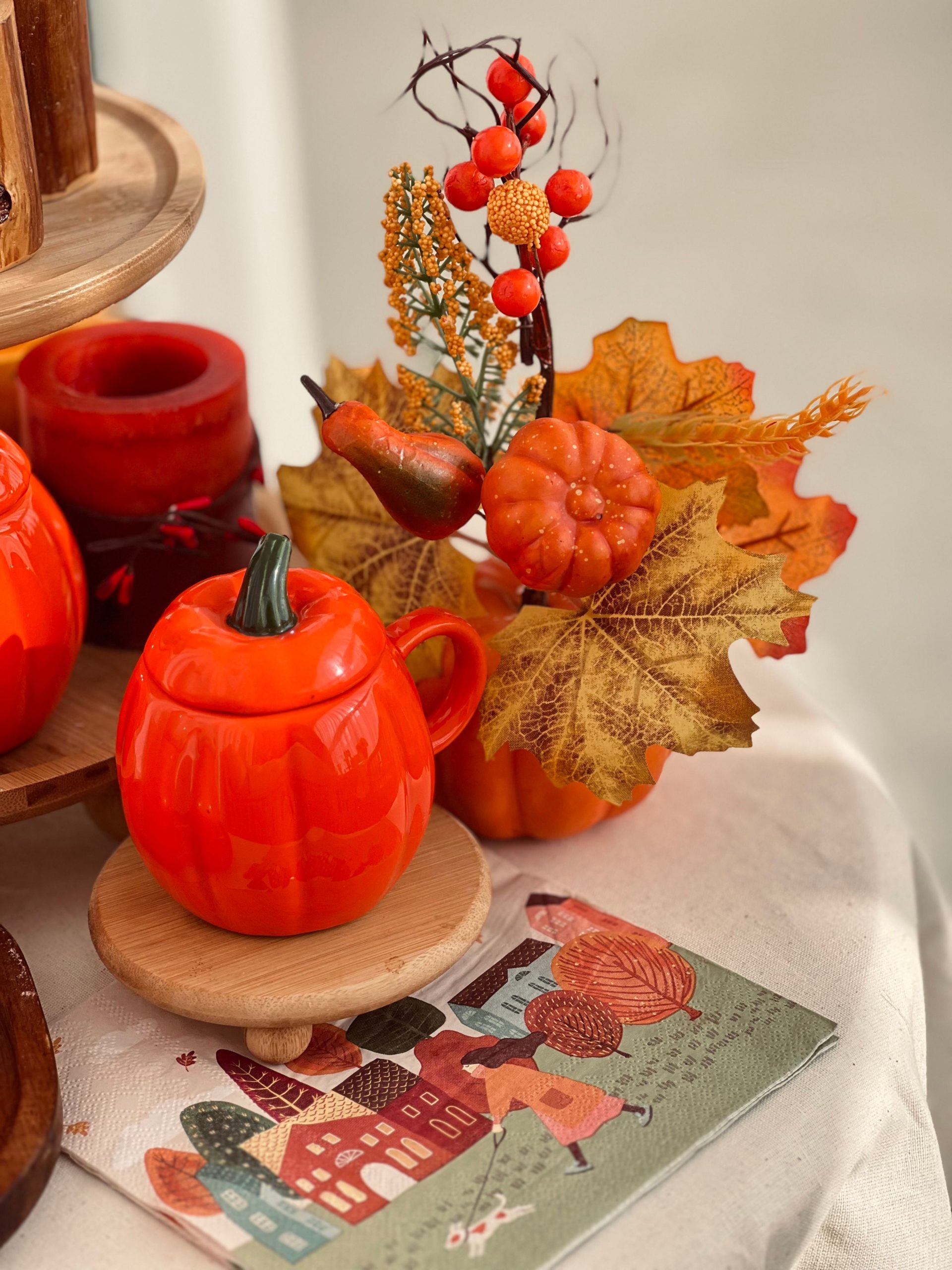 Festive autumn table setting with pumpkins, leaves, and candles.