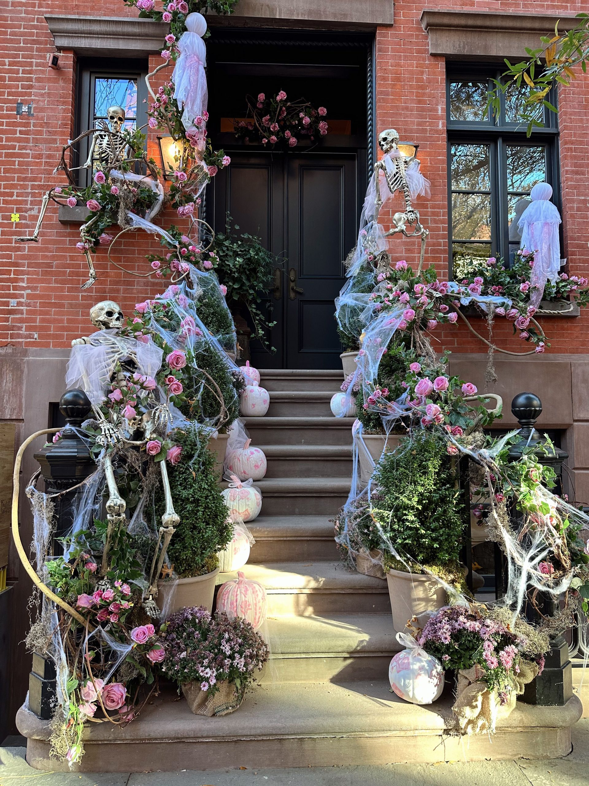 Halloween-themed brownstone in New York with skeletons and floral decor.