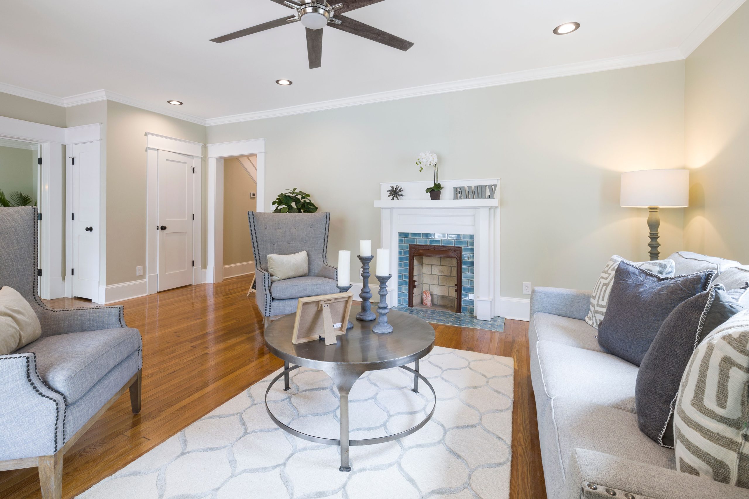 Modern living room featuring a fireplace, elegant furniture, and warm hardwood floors.