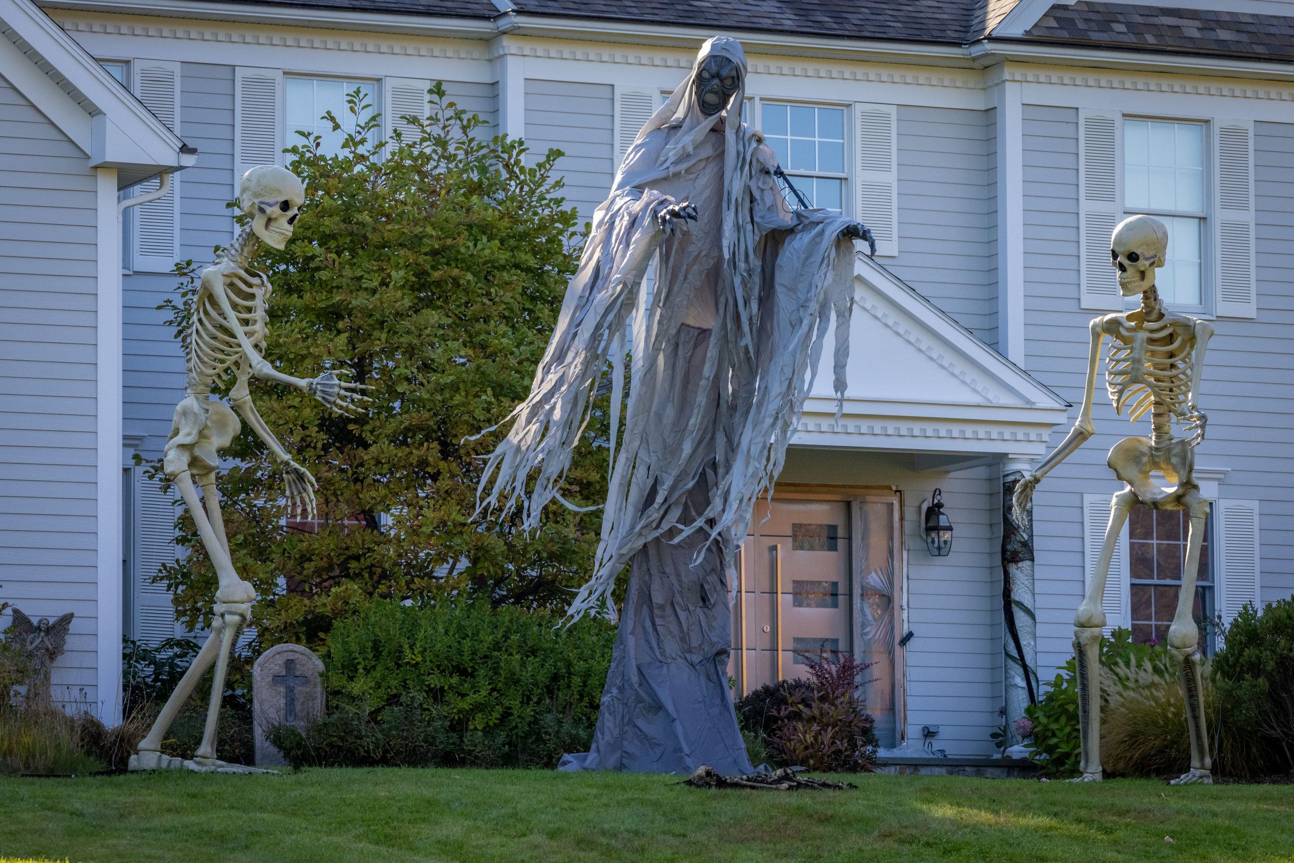 Scary skeleton and reaper decorations in a Grafton, MA yard during Halloween.