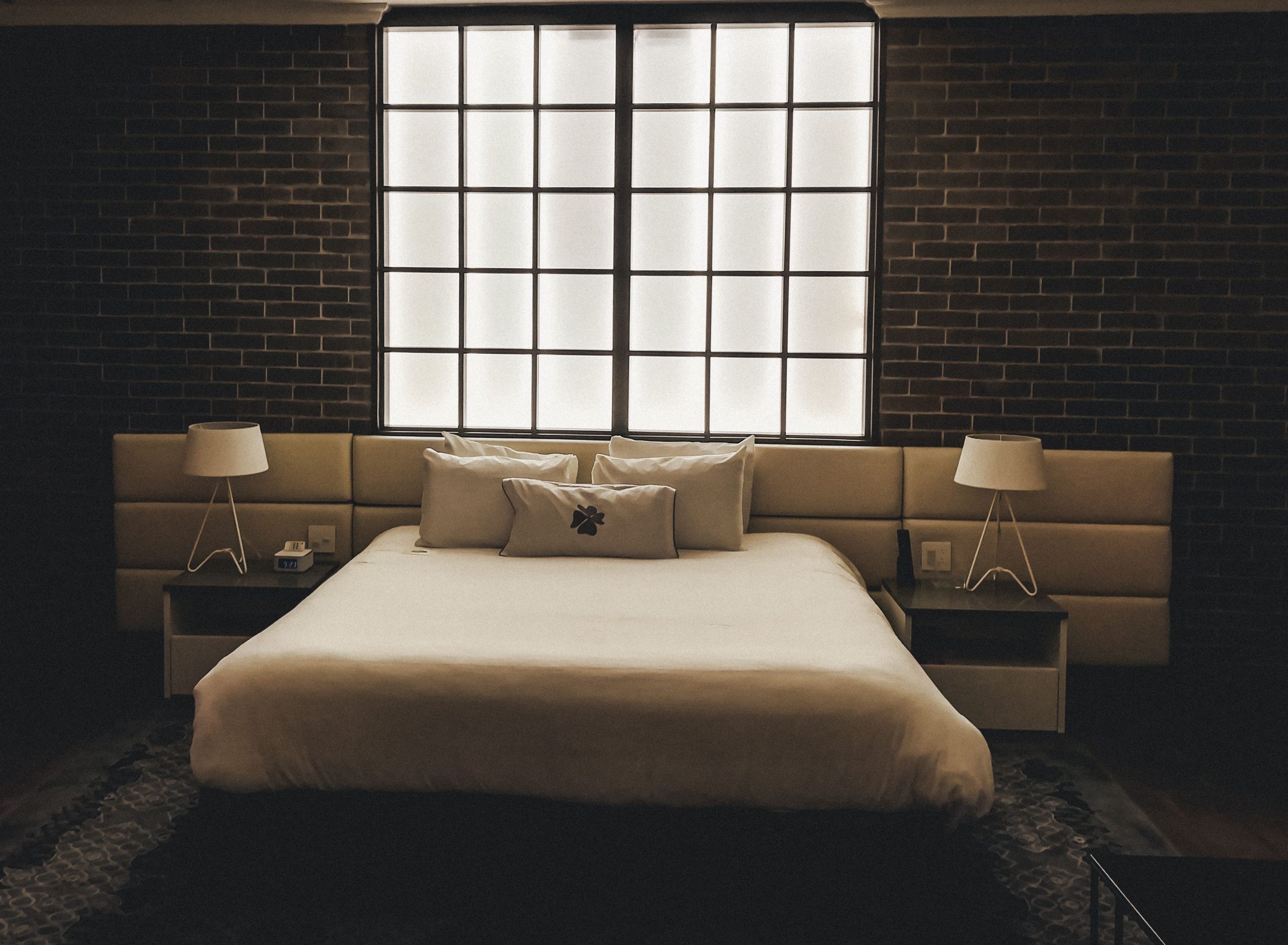 Stylish bedroom featuring a brick wall, modern design, and ambient lighting.