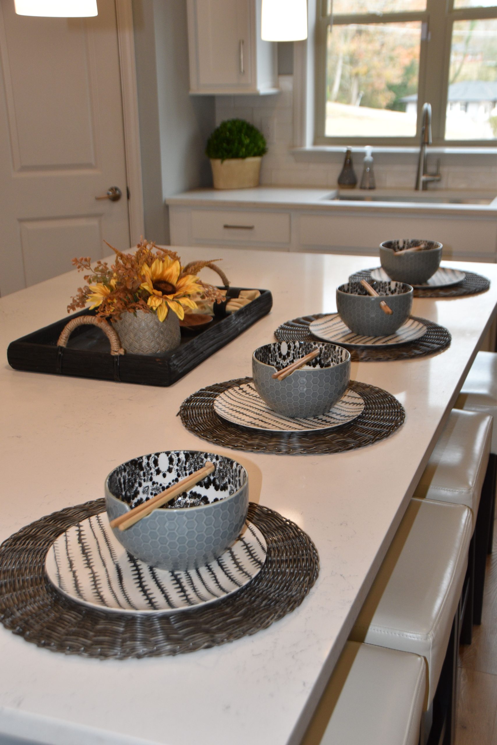 Stylish kitchen island with bowls and autumn decor on a white countertop.