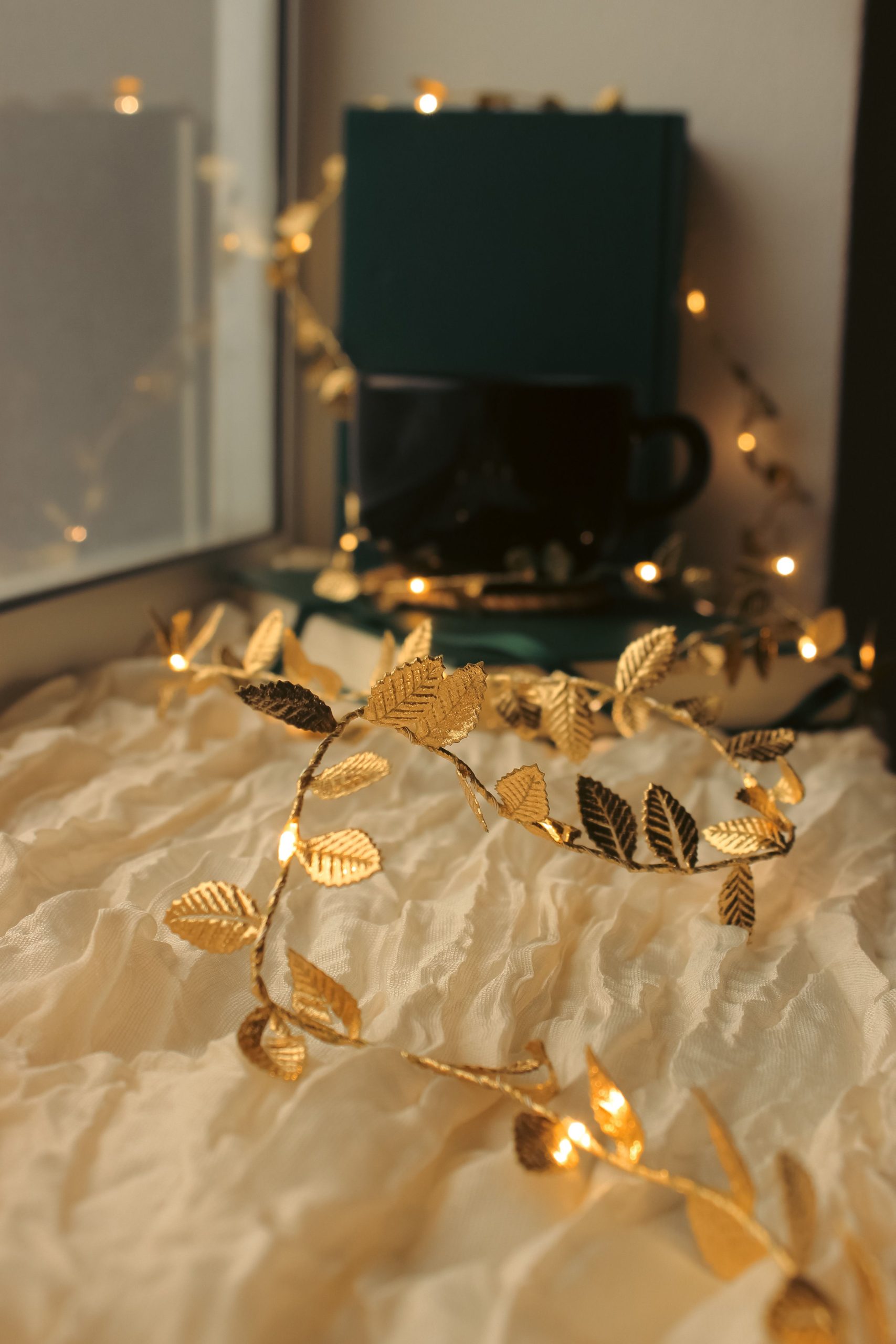 Warm and cozy autumn still life with fairy lights and a mug, perfect for seasonal ambiance.