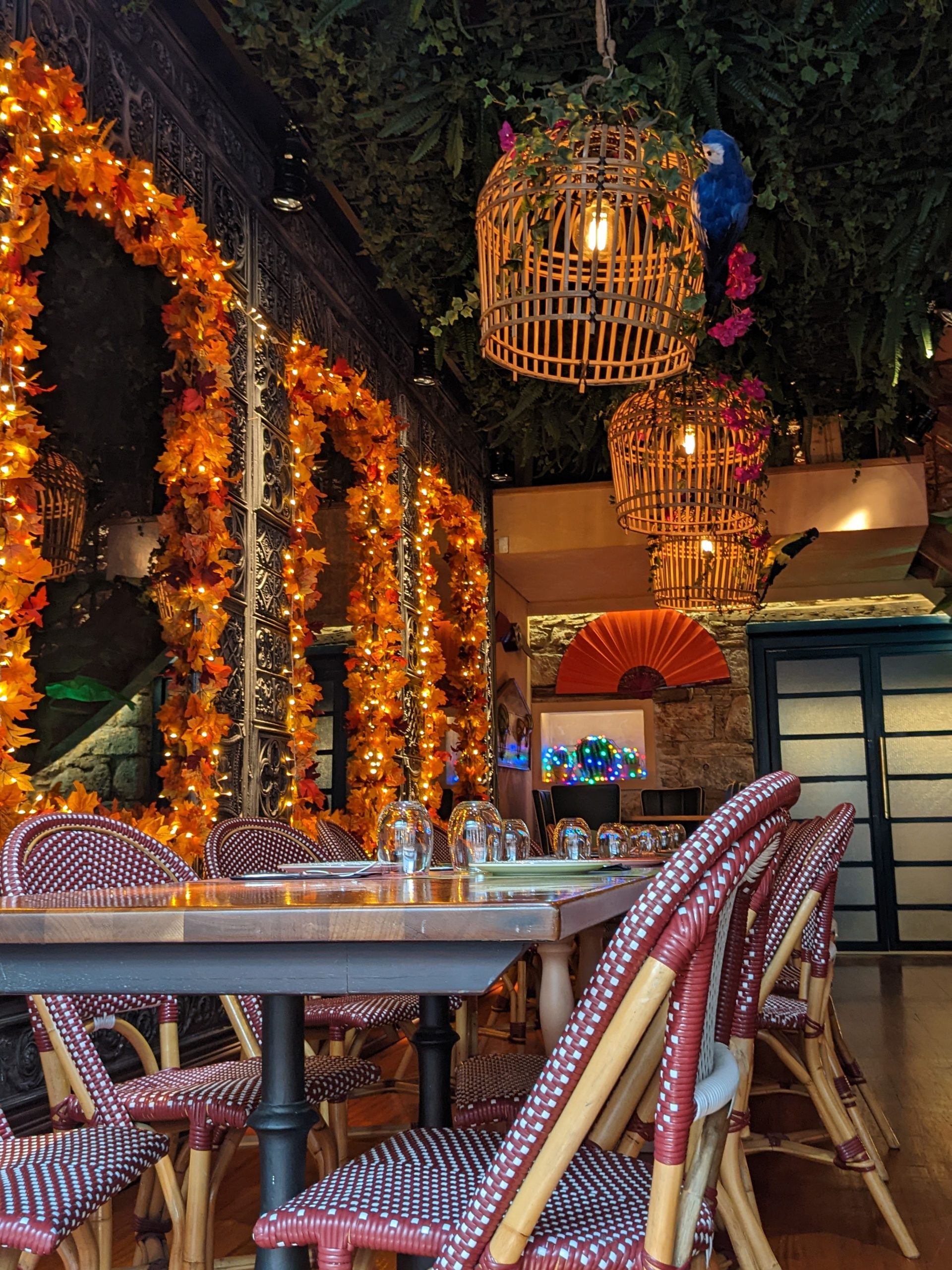 Warm and inviting restaurant setting with vibrant autumn decorations and rattan accents.