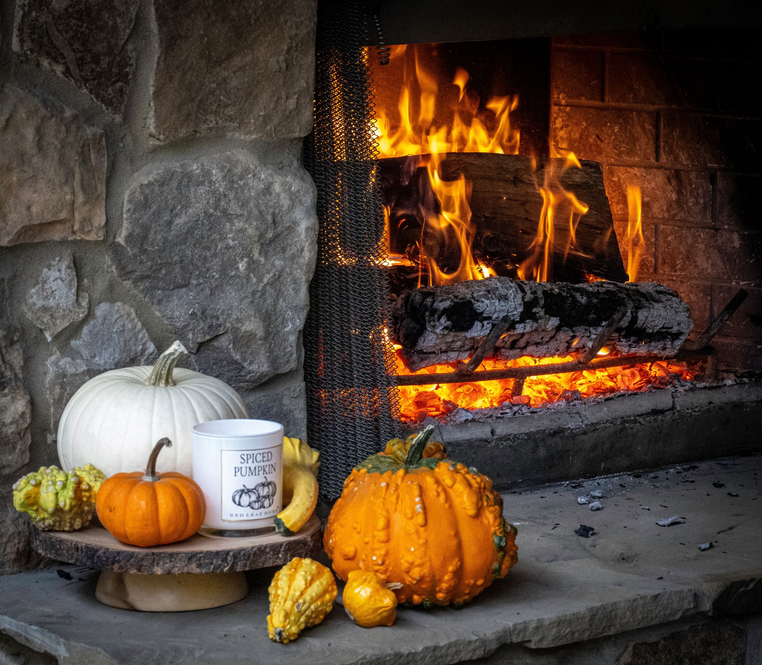Warm autumn setting with pumpkins and a cozy fireplace, perfect for fall ambiance.