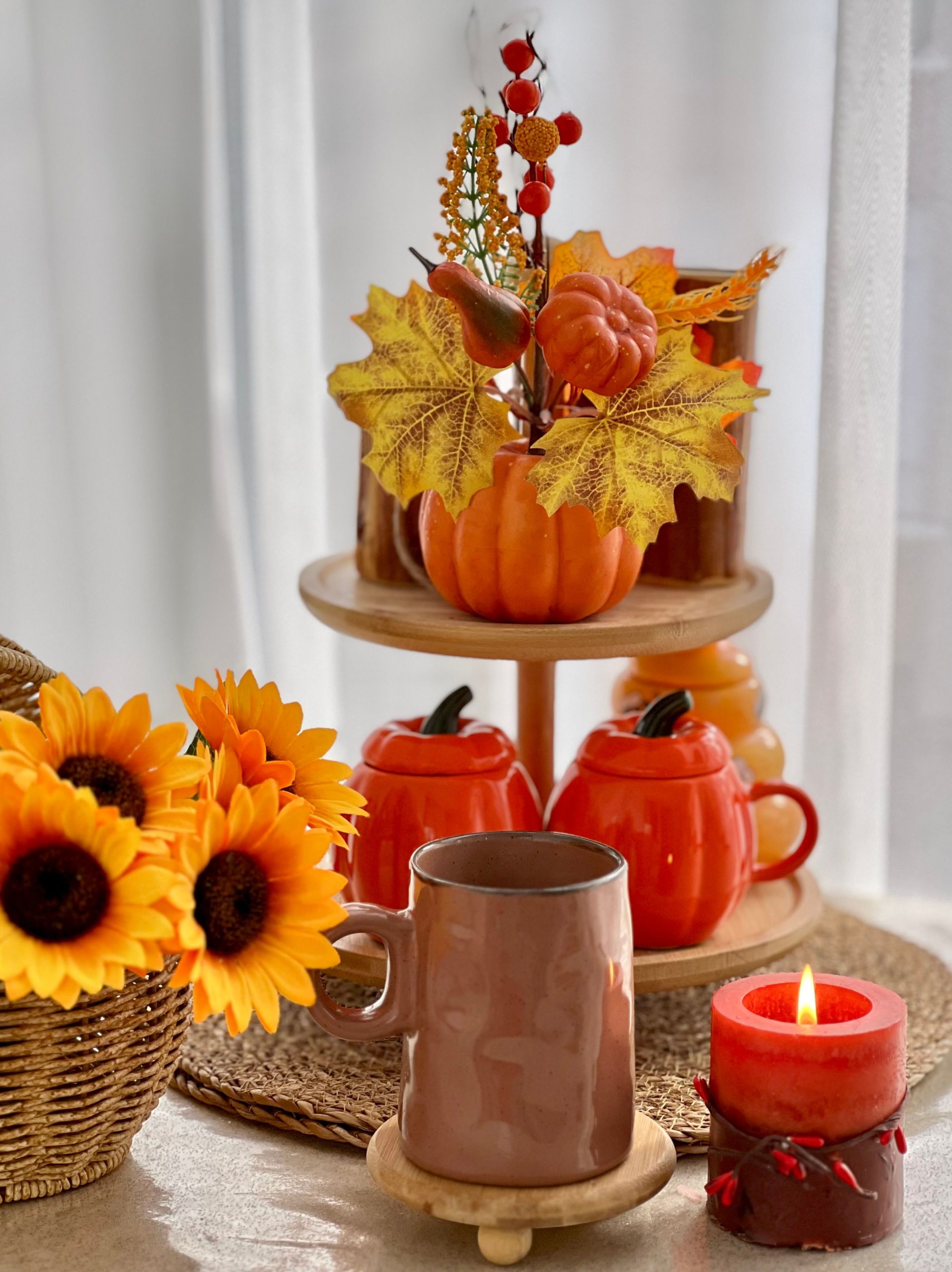 Warm autumn setup with pumpkins, sunflowers, and candles for a cozy fall atmosphere.