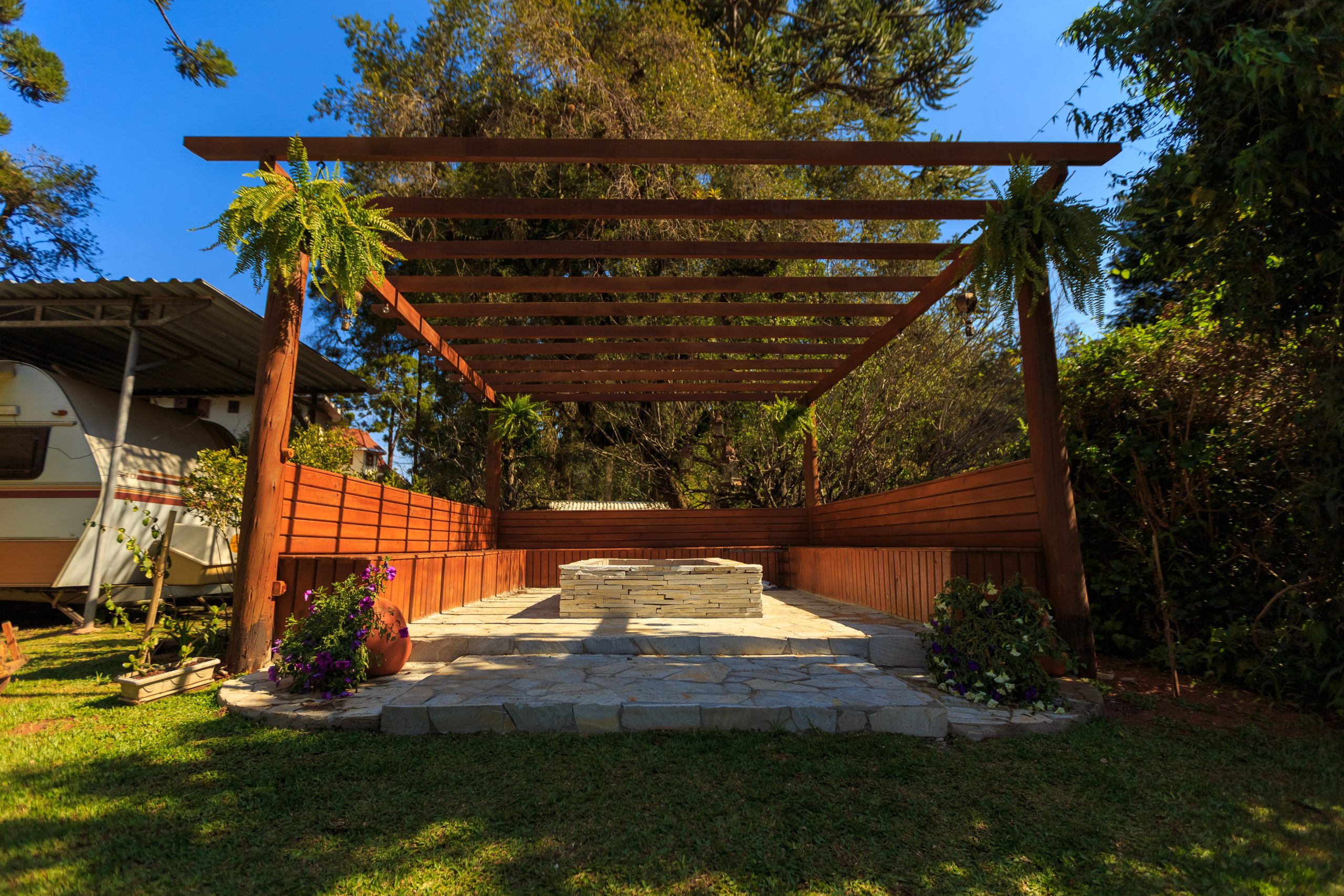 A beautiful wooden gazebo set amidst lush green garden, ideal for outdoor relaxation.