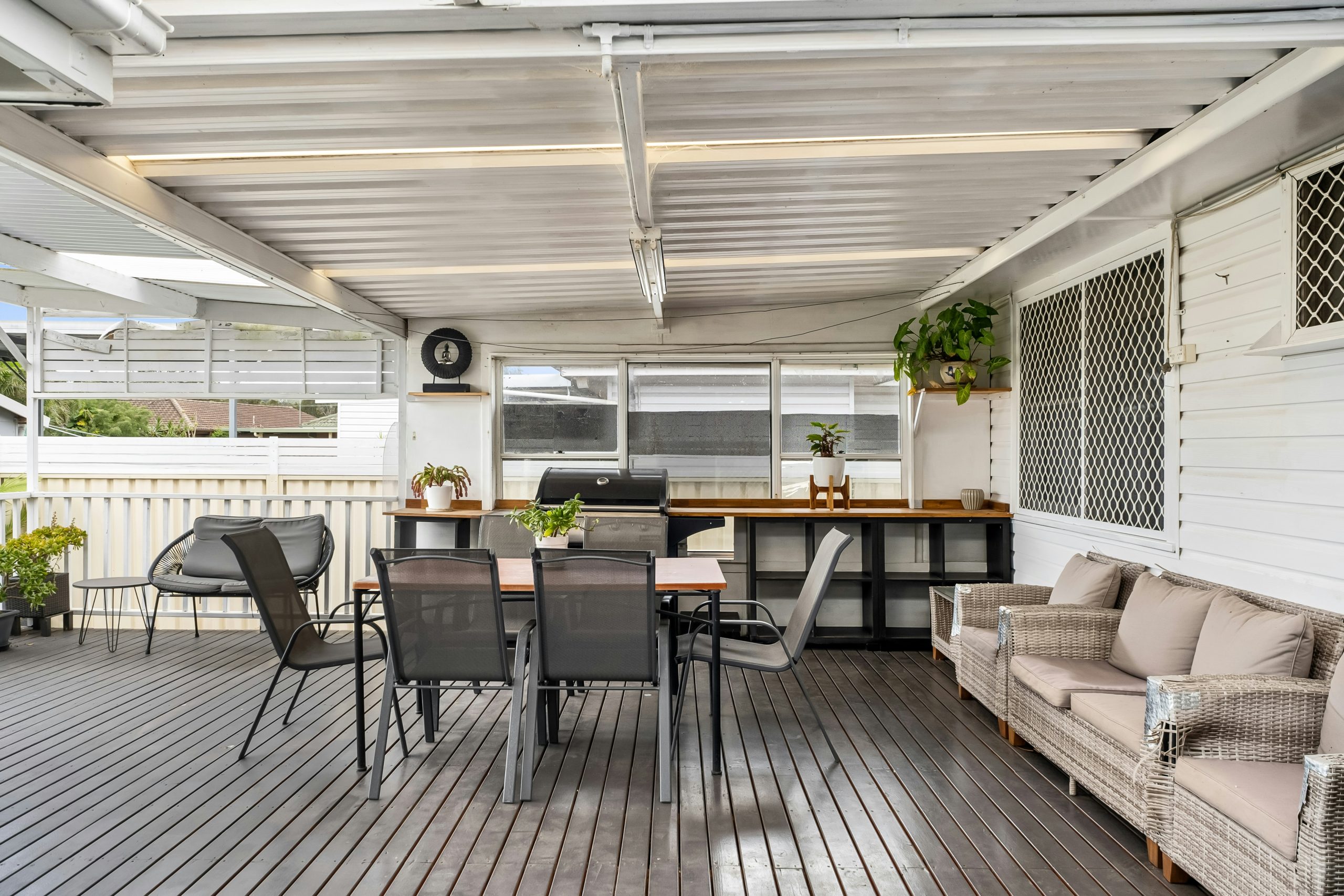 A covered patio with a table and chairs