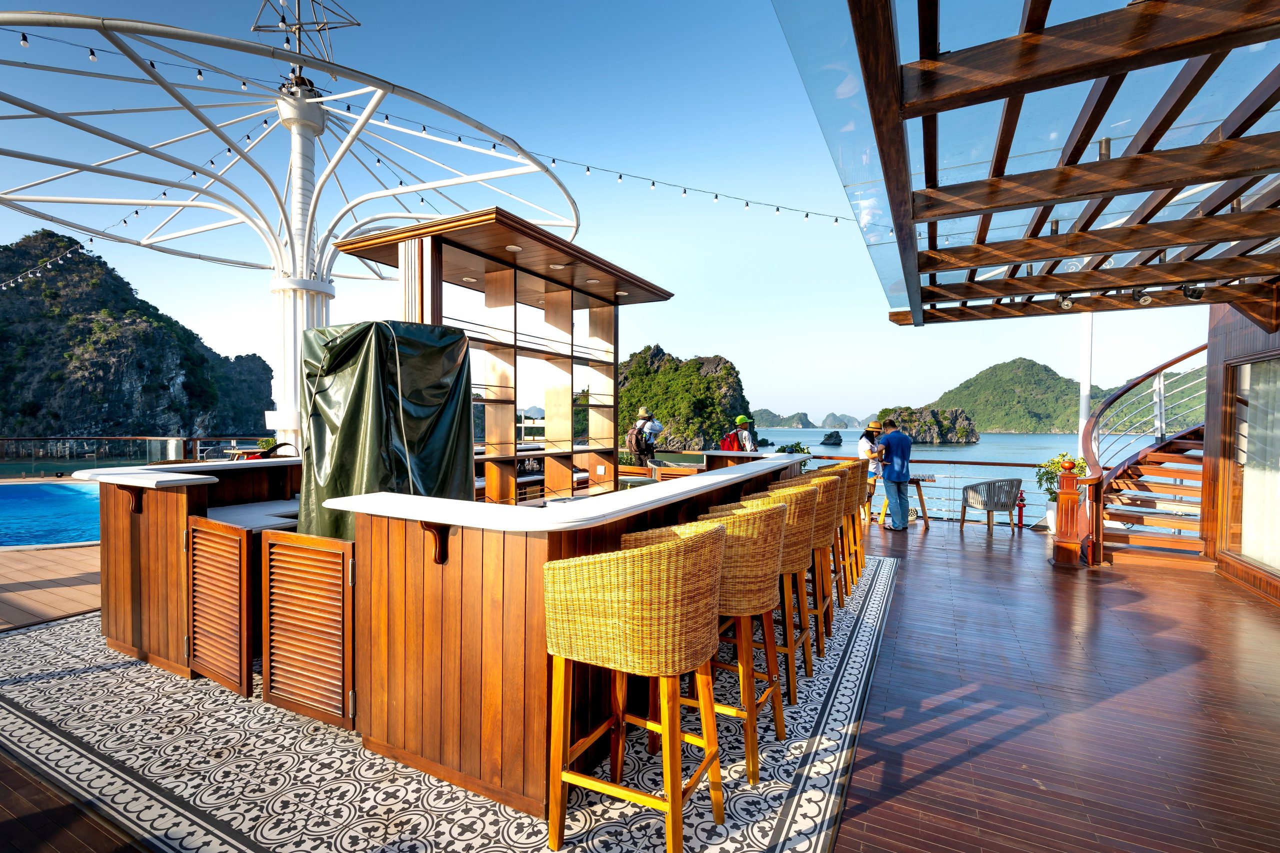 A luxurious outdoor bar on a deck with scenic ocean views, perfect for travel and relaxation.