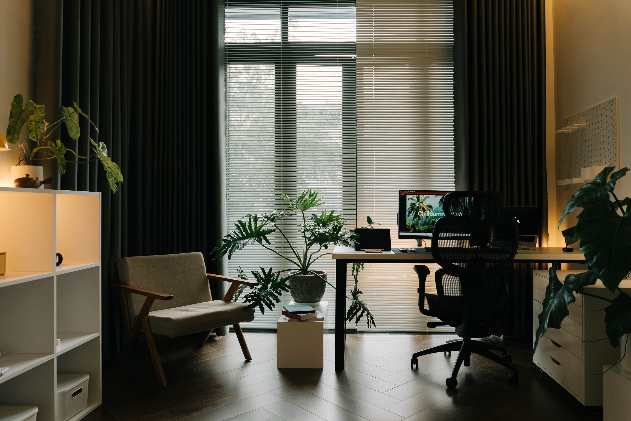 A stylish home office featuring indoor plants, natural light, and a modern workspace.