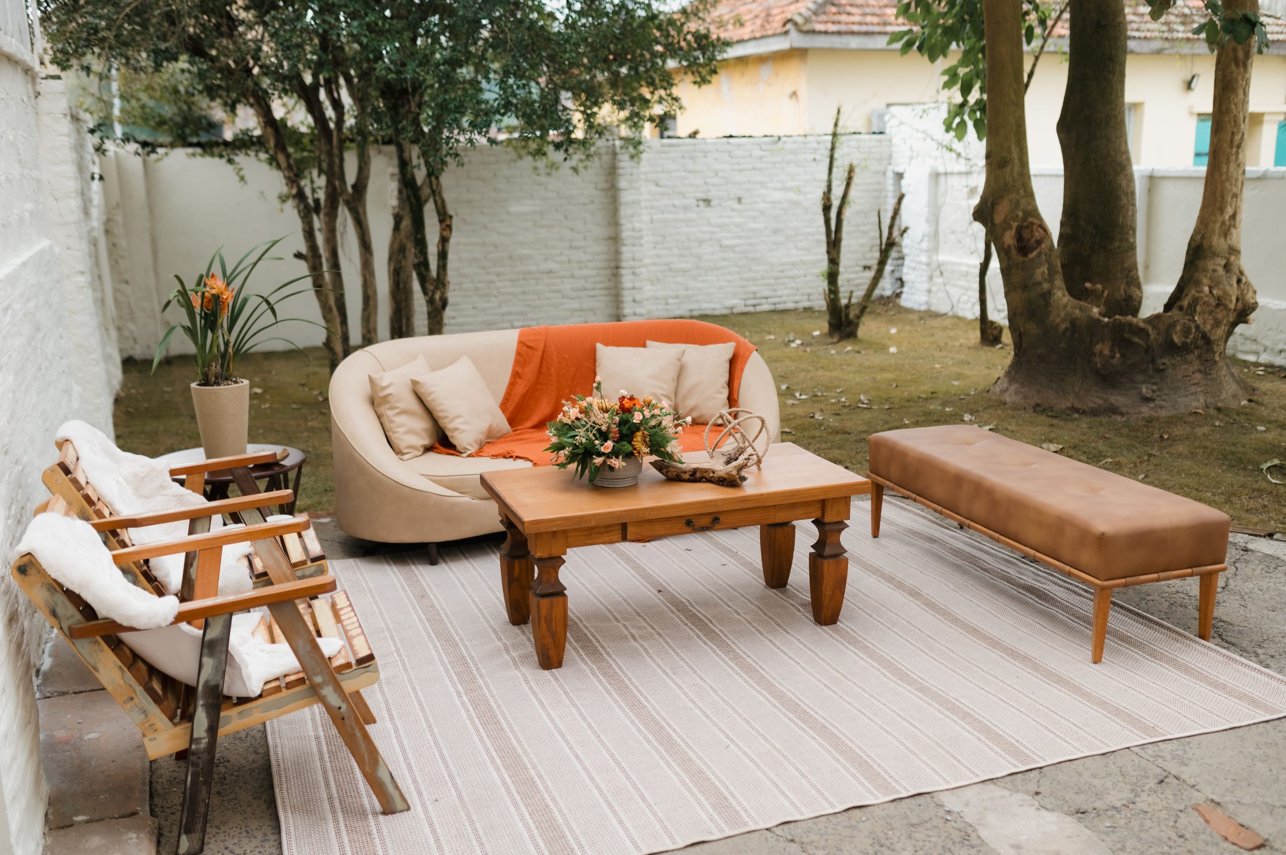 A stylish outdoor patio setup with modern furniture and natural decor, perfect for relaxation and gatherings.