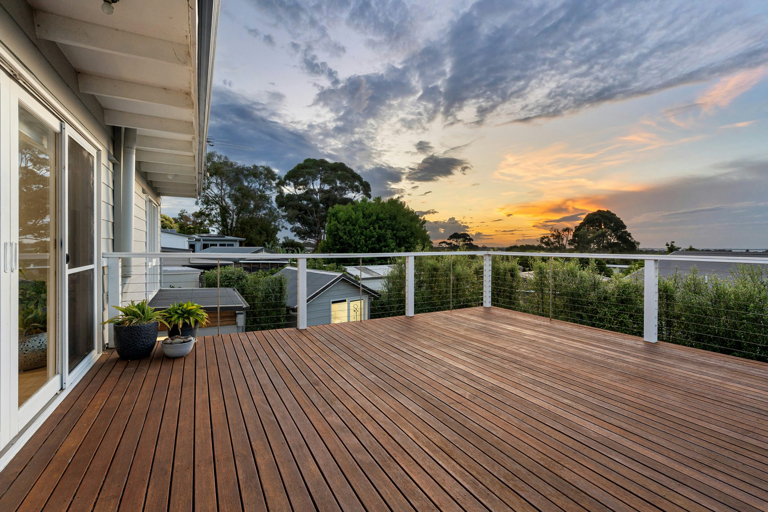 A wooden deck with a potted plant on it