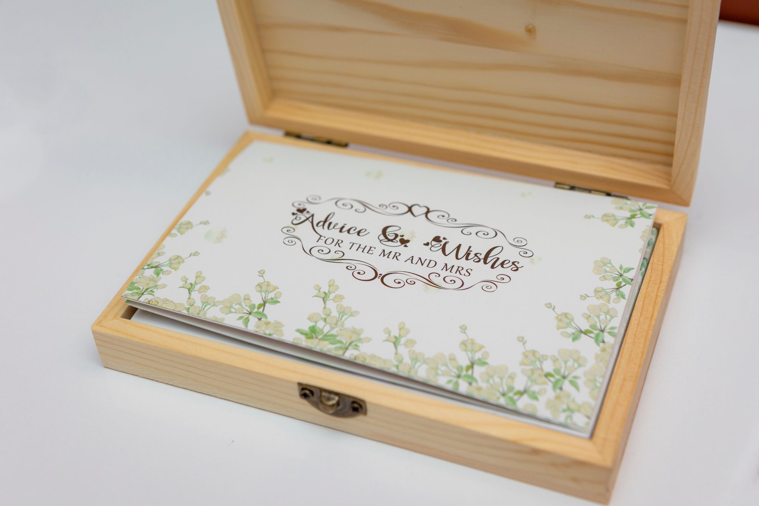 An elegant wooden box containing advice and wishes for the newlyweds, featuring floral designs.