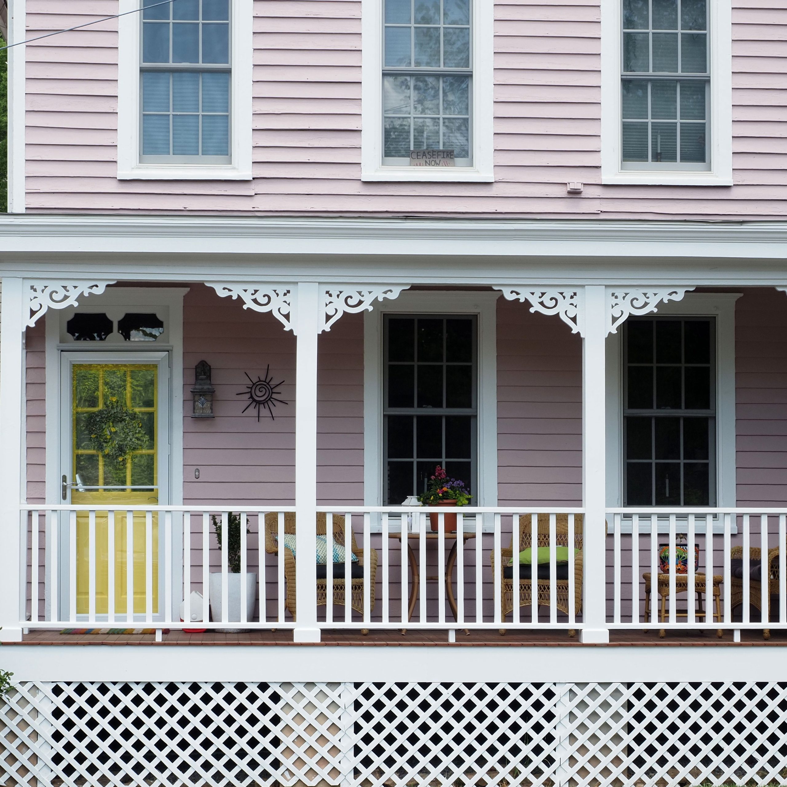 Beautiful pink house with a cozy porch featuring ornate trim, located in Stockton, New Jersey.