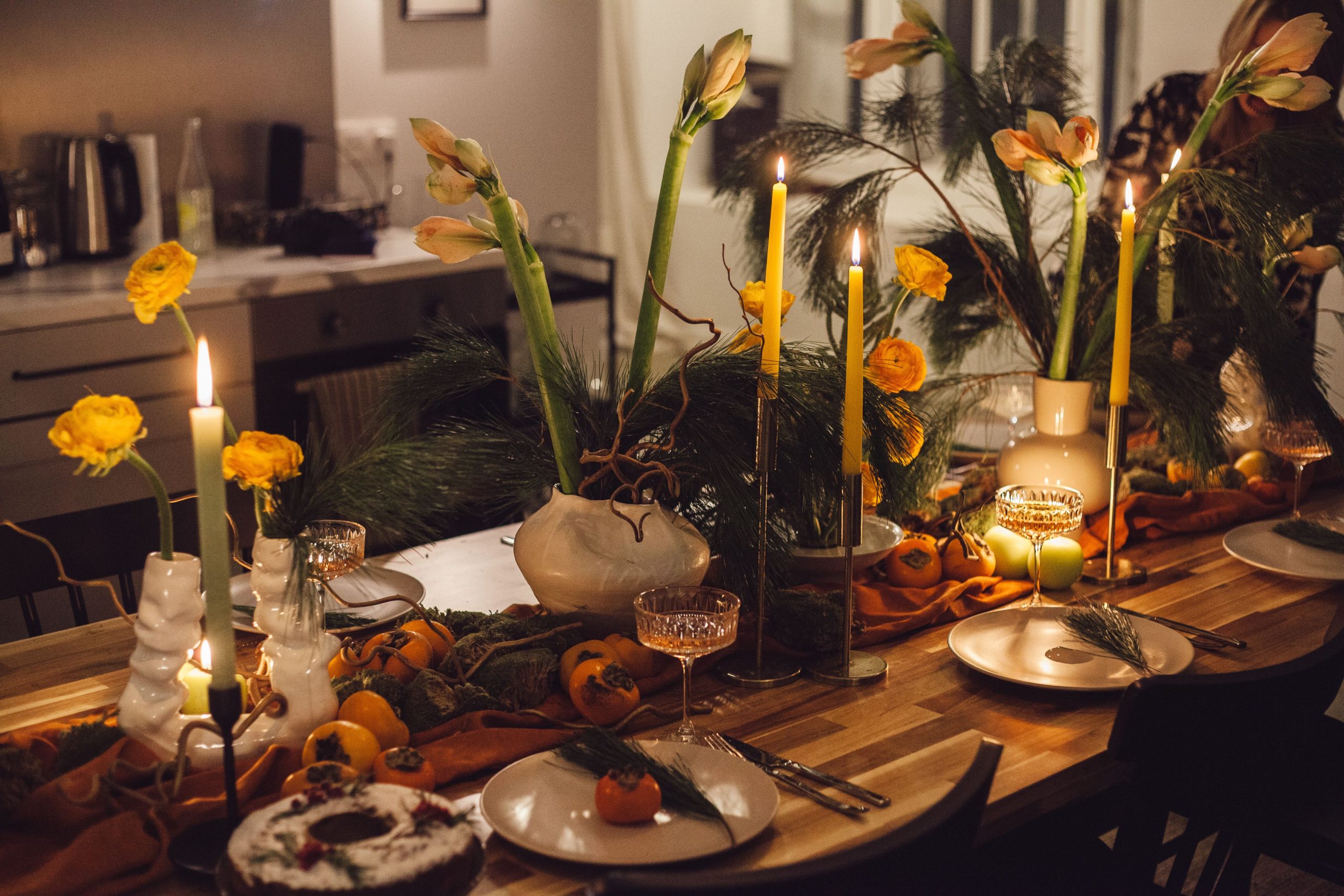 Beautifully decorated dinner table with candles, flowers, and elegant decor, creating a warm ambiance.