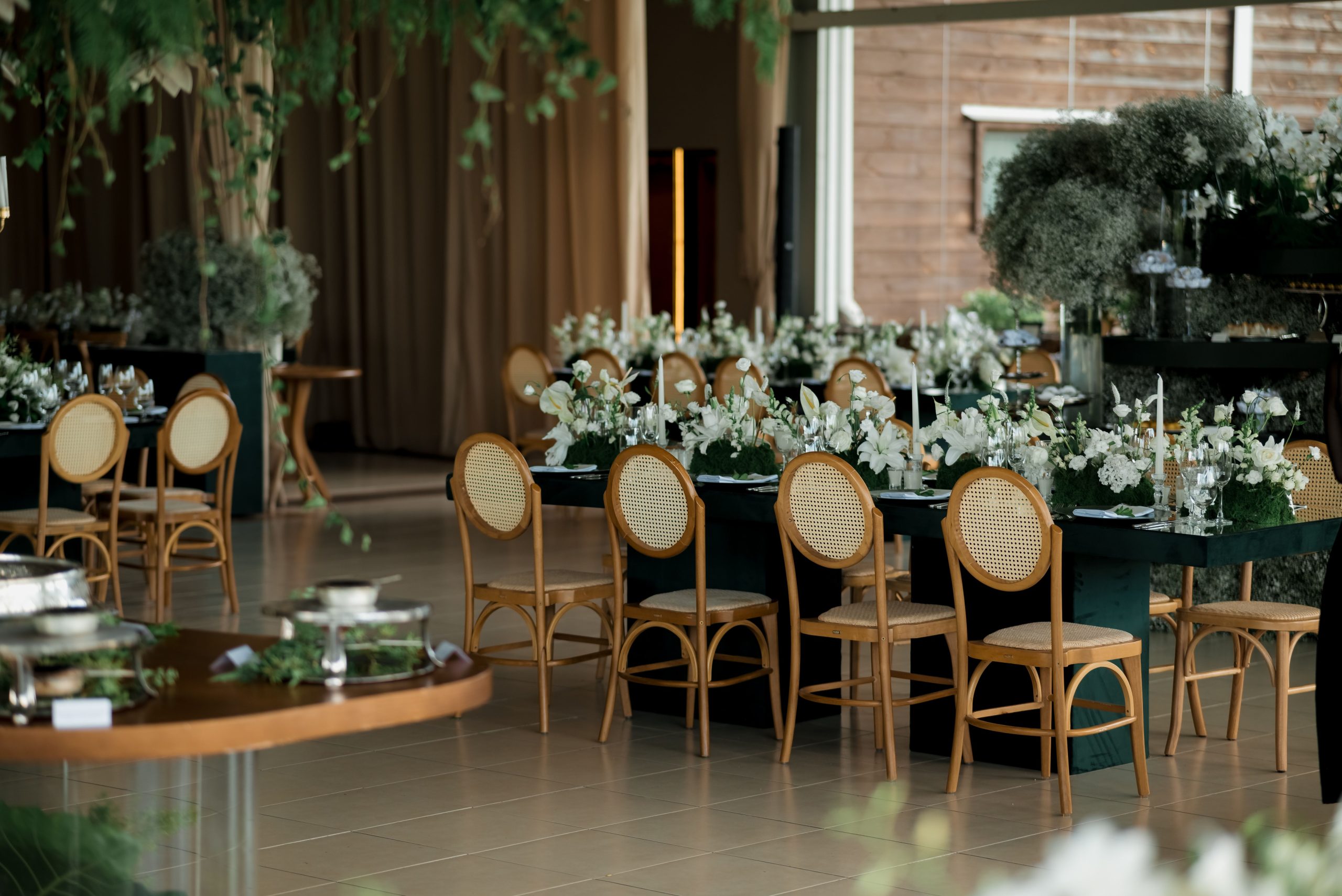 Beautifully decorated indoor wedding reception with floral arrangements and elegant seating.