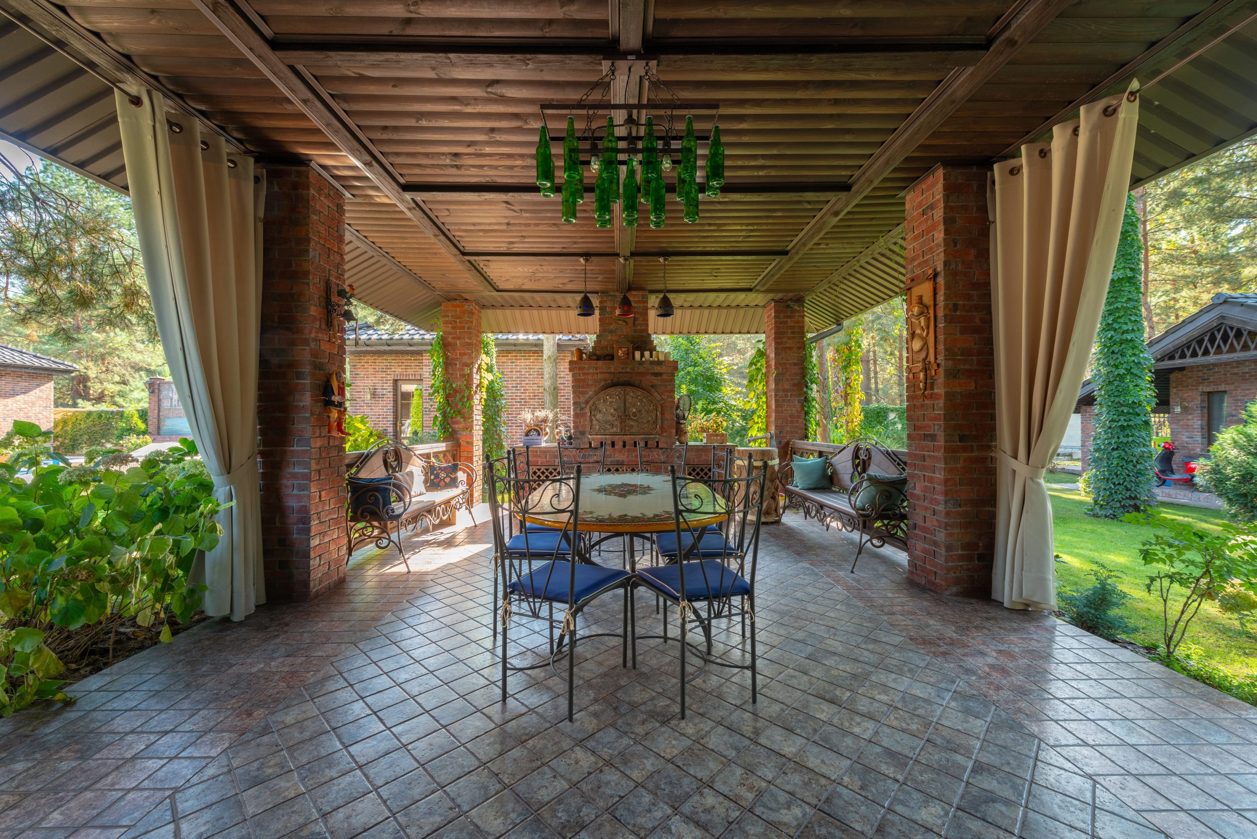 Charming patio with wrought iron furniture, brick walls, and garden view, ideal for relaxing outdoors.