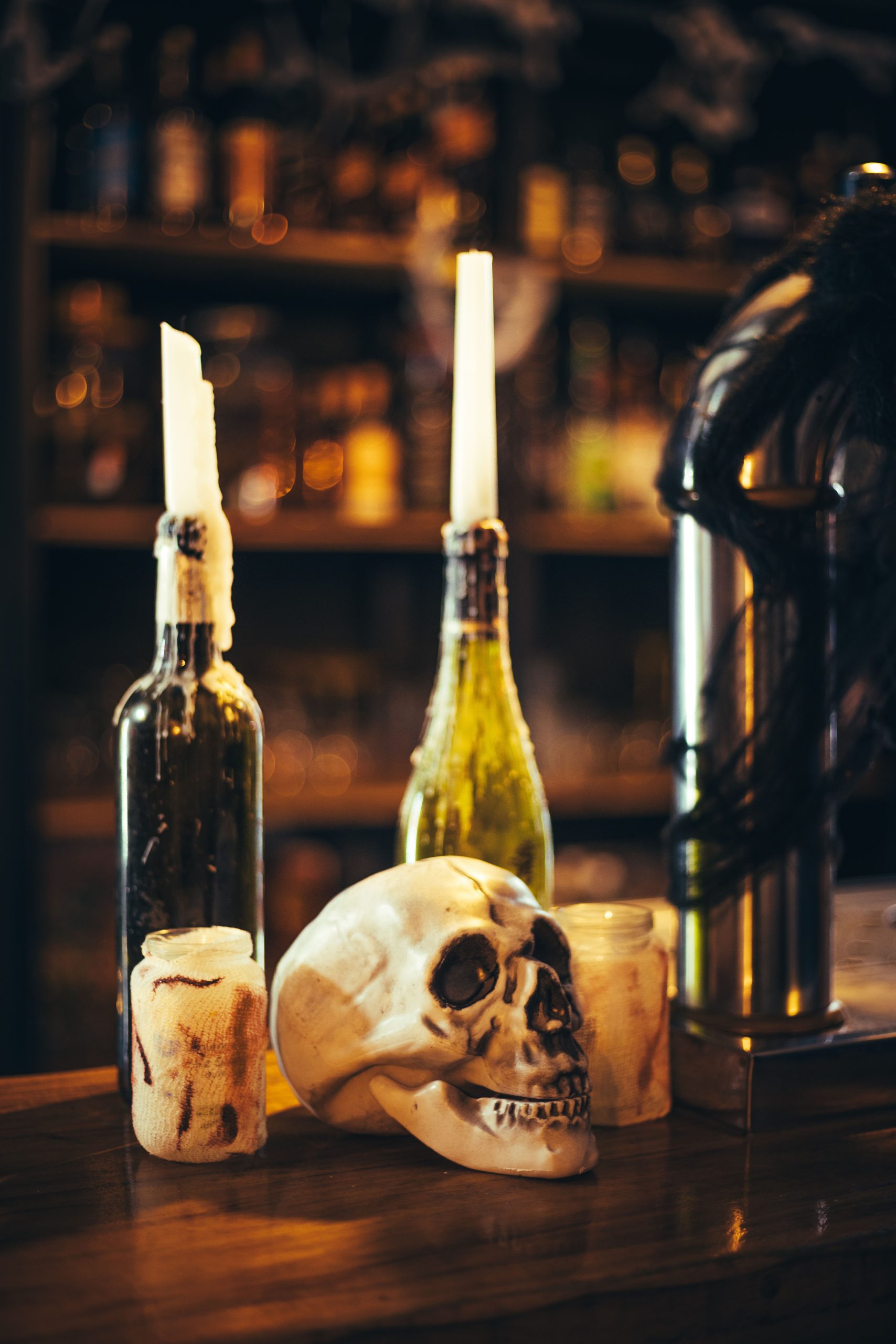 Chilling Halloween bar arrangement with skull and candles, perfect for eerie decor inspirations.