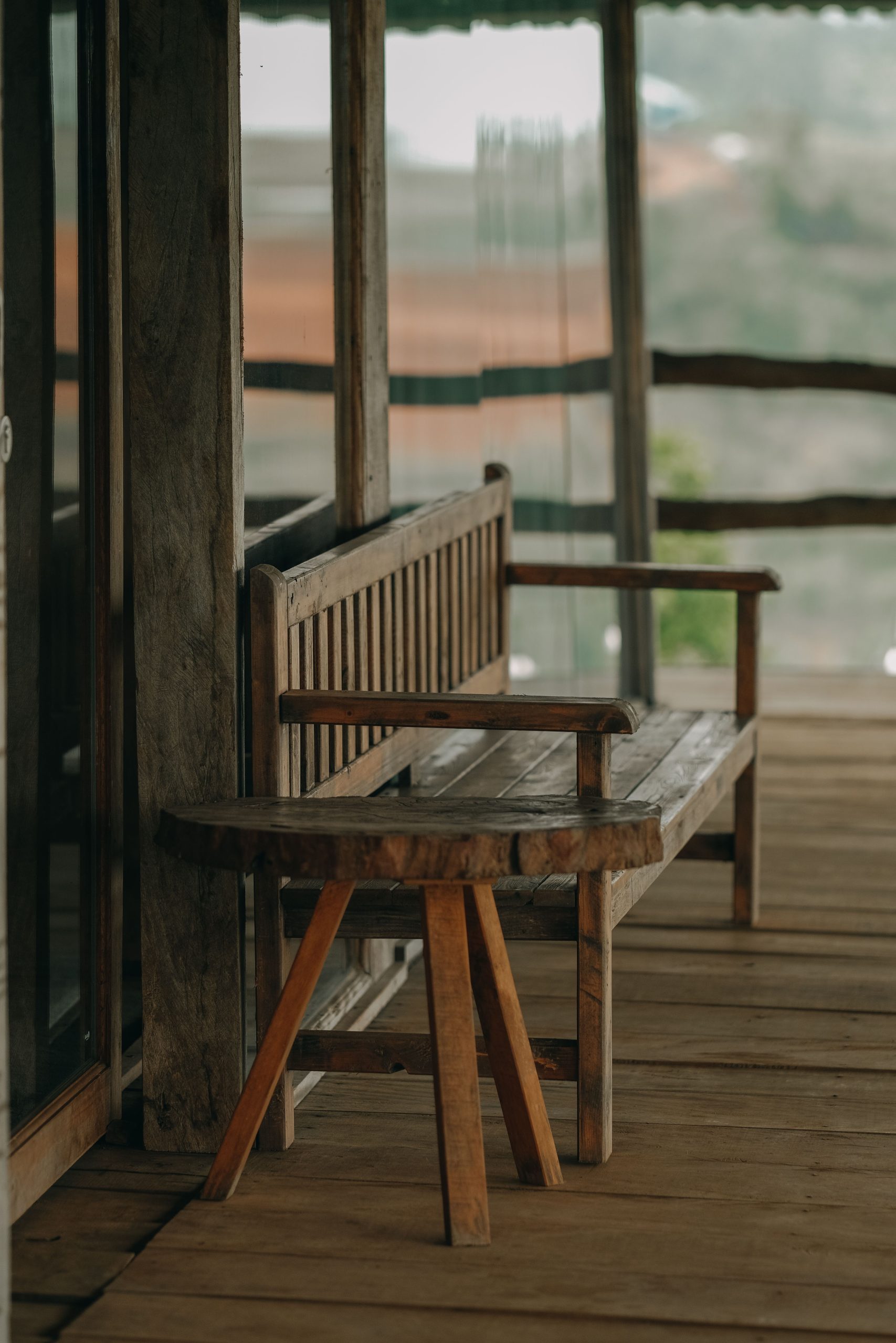 Cozy rustic wooden bench on outdoor patio with serene view.