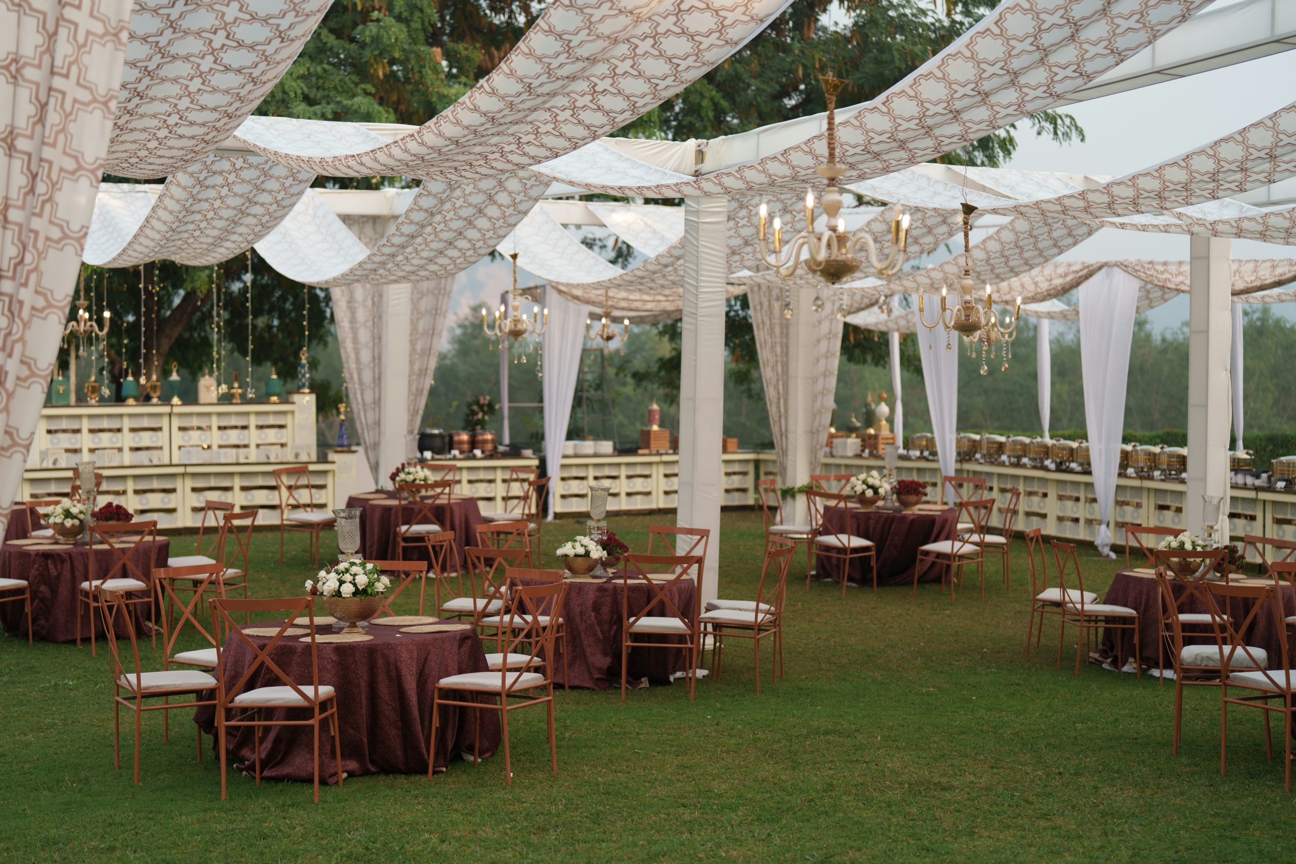 Elegant outdoor wedding reception with draped canopy and tables
