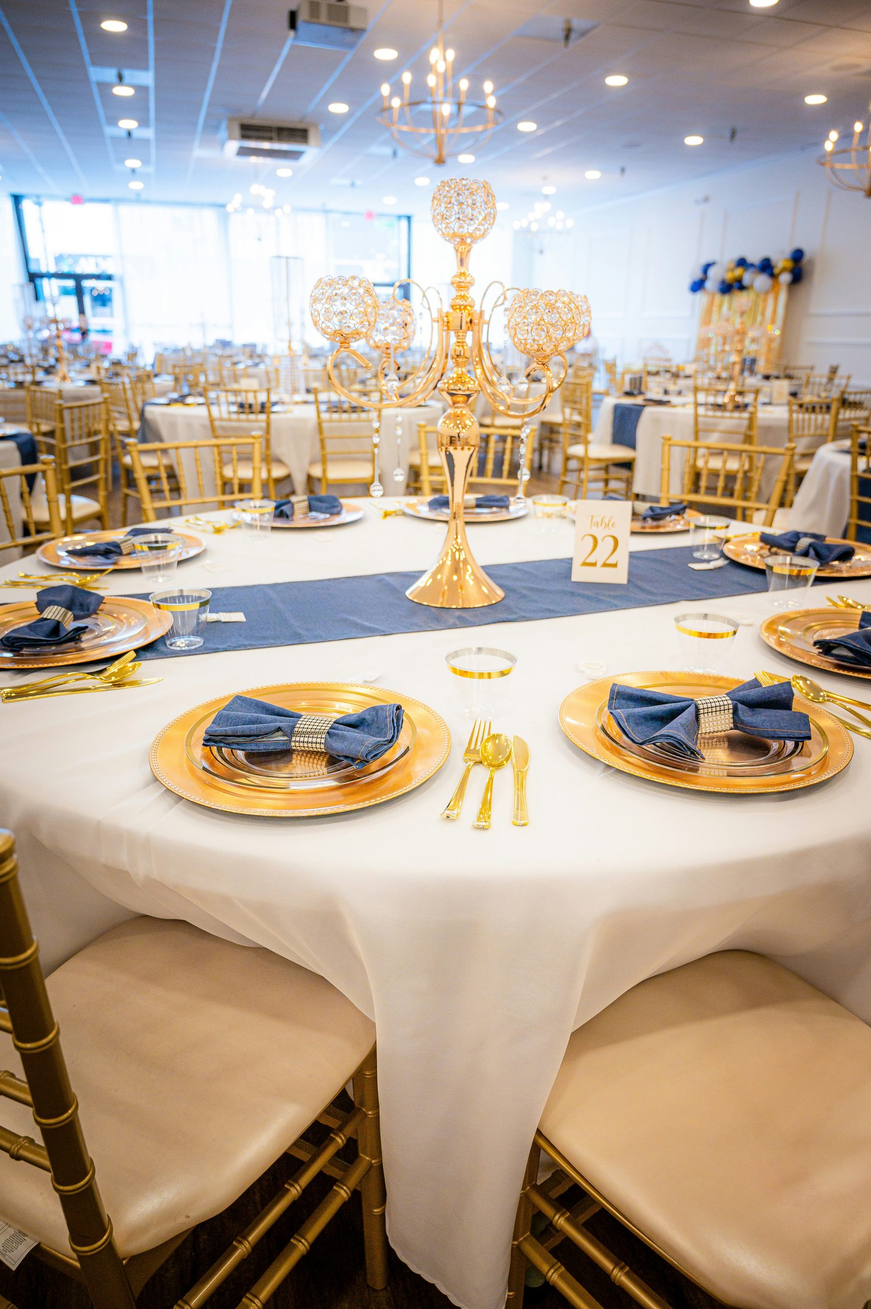 Elegant table setting with gold chairs and blue napkins