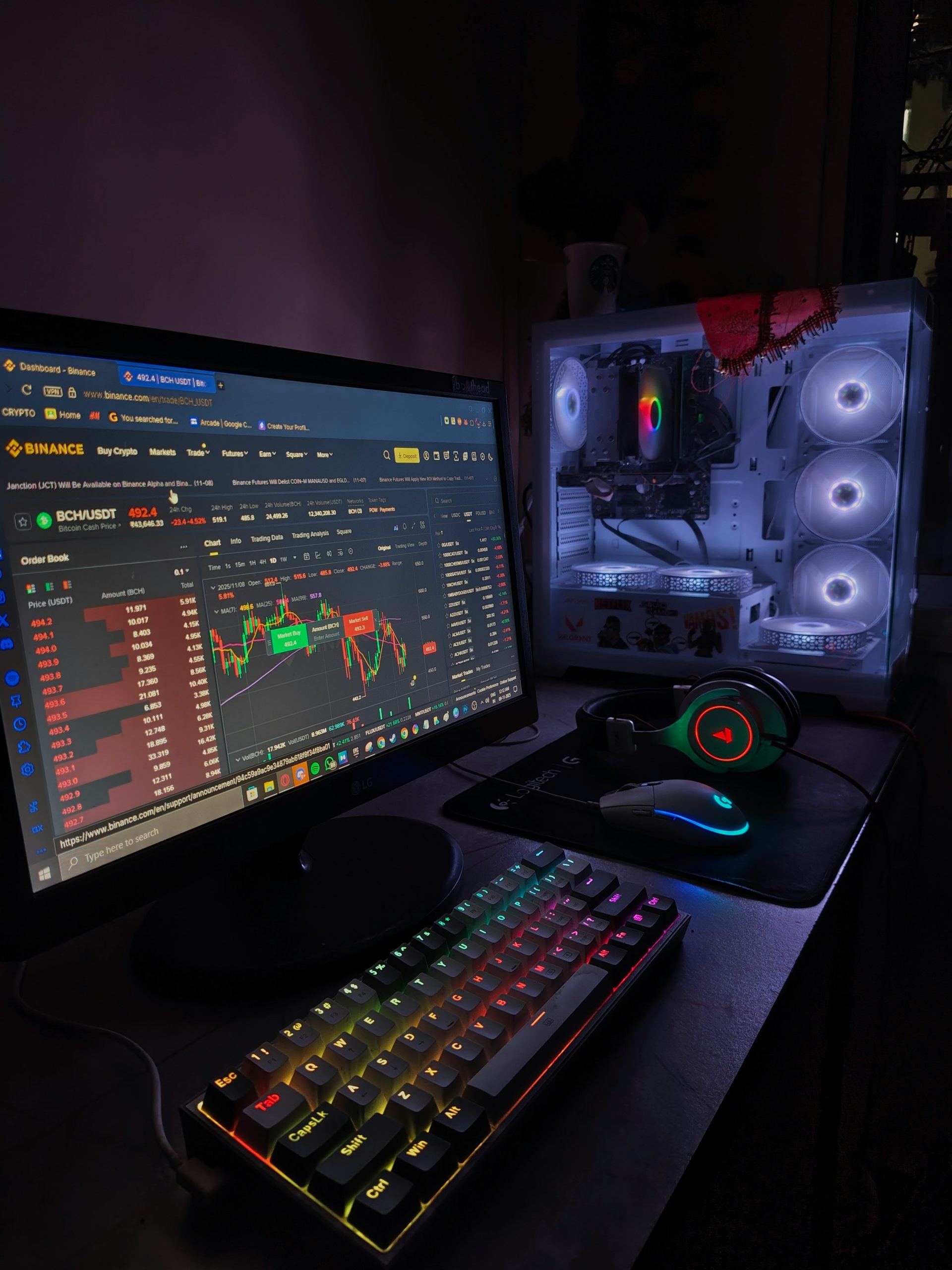 Gaming PC setup with financial charts on monitor at night