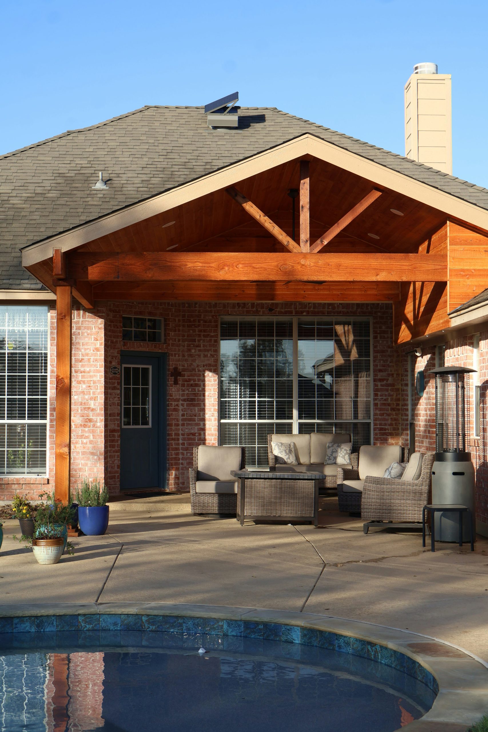 House exterior with covered patio, outdoor furniture, and swimming pool