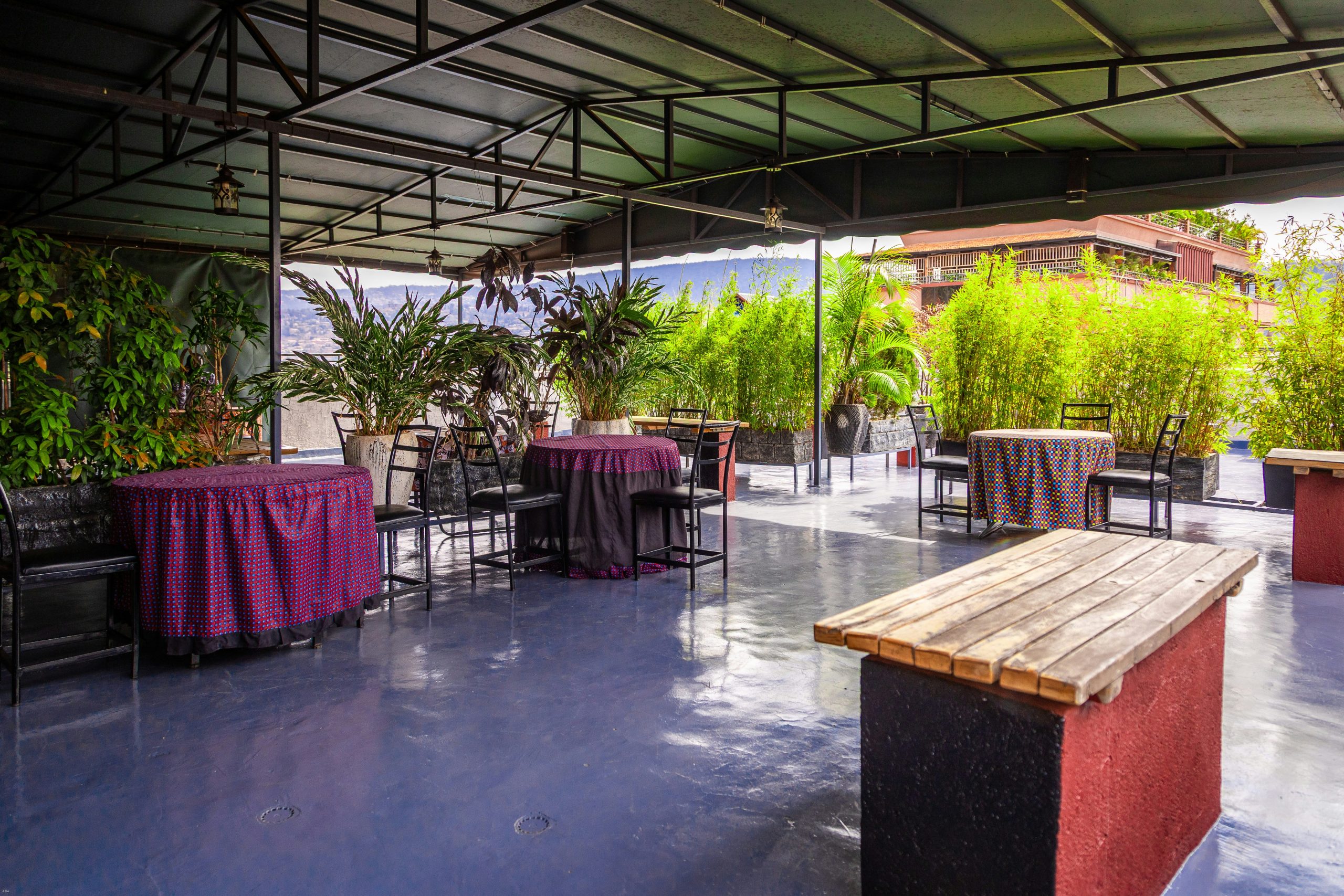 Outdoor patio with tables, chairs, plants, and a bar