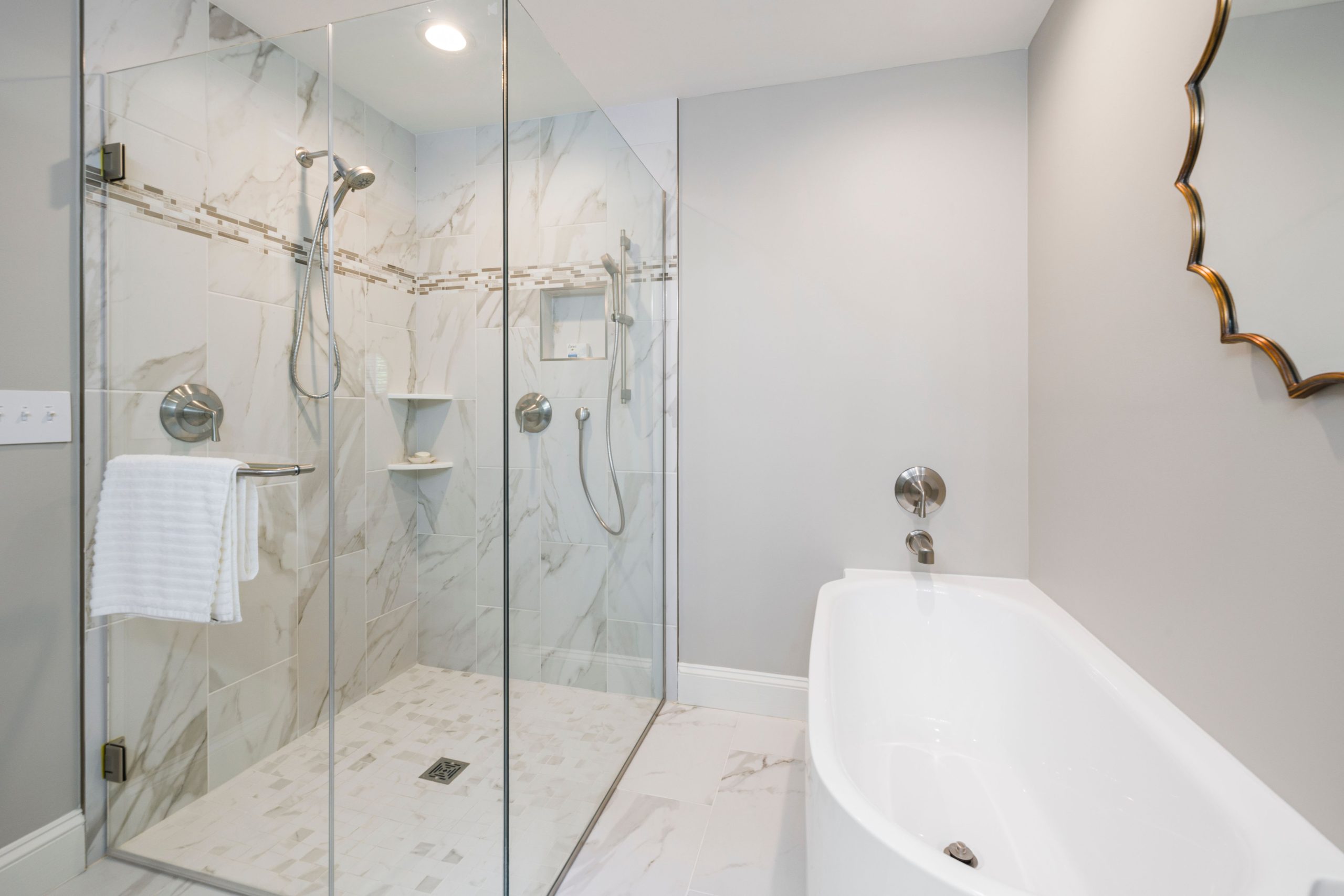 Sleek bathroom featuring a glass shower and freestanding bathtub, ideal for contemporary home decor.